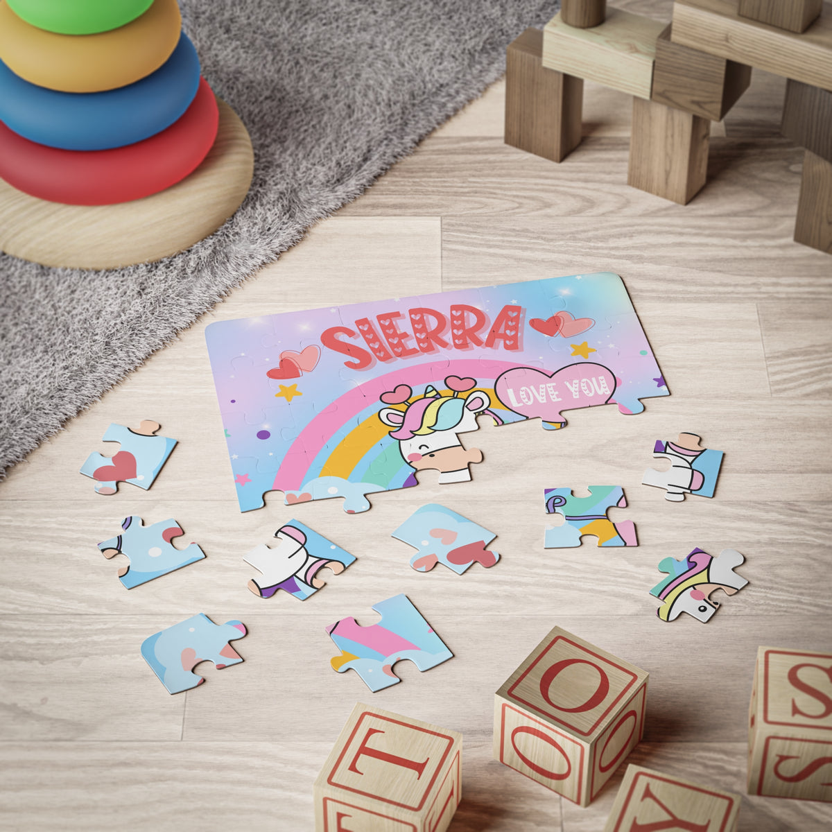 Personalized unicorn jigsaw puzzle with a customizable name across the top, shown in use during playtime. The customer-selected name appears on the puzzle design, making it a personalized puzzle for children.