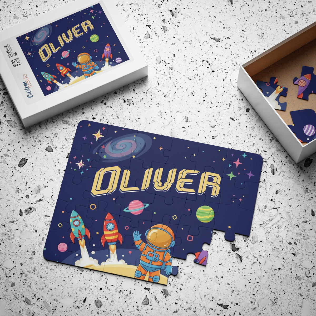 Custom name space puzzle for kids displayed next to its box packaging, showing a cartoon astronaut, rockets, planets, and a dark starry background.