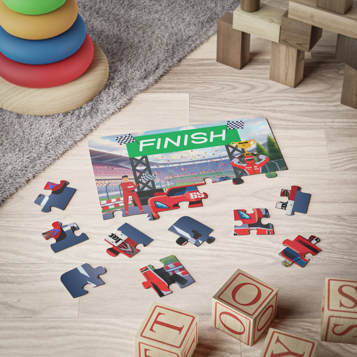 Personalized kids racecar jigsaw puzzle scene with scattered pieces on the floor, showing a finish line stadium design with a customizable child’s name displayed on the racecar’s license plate.