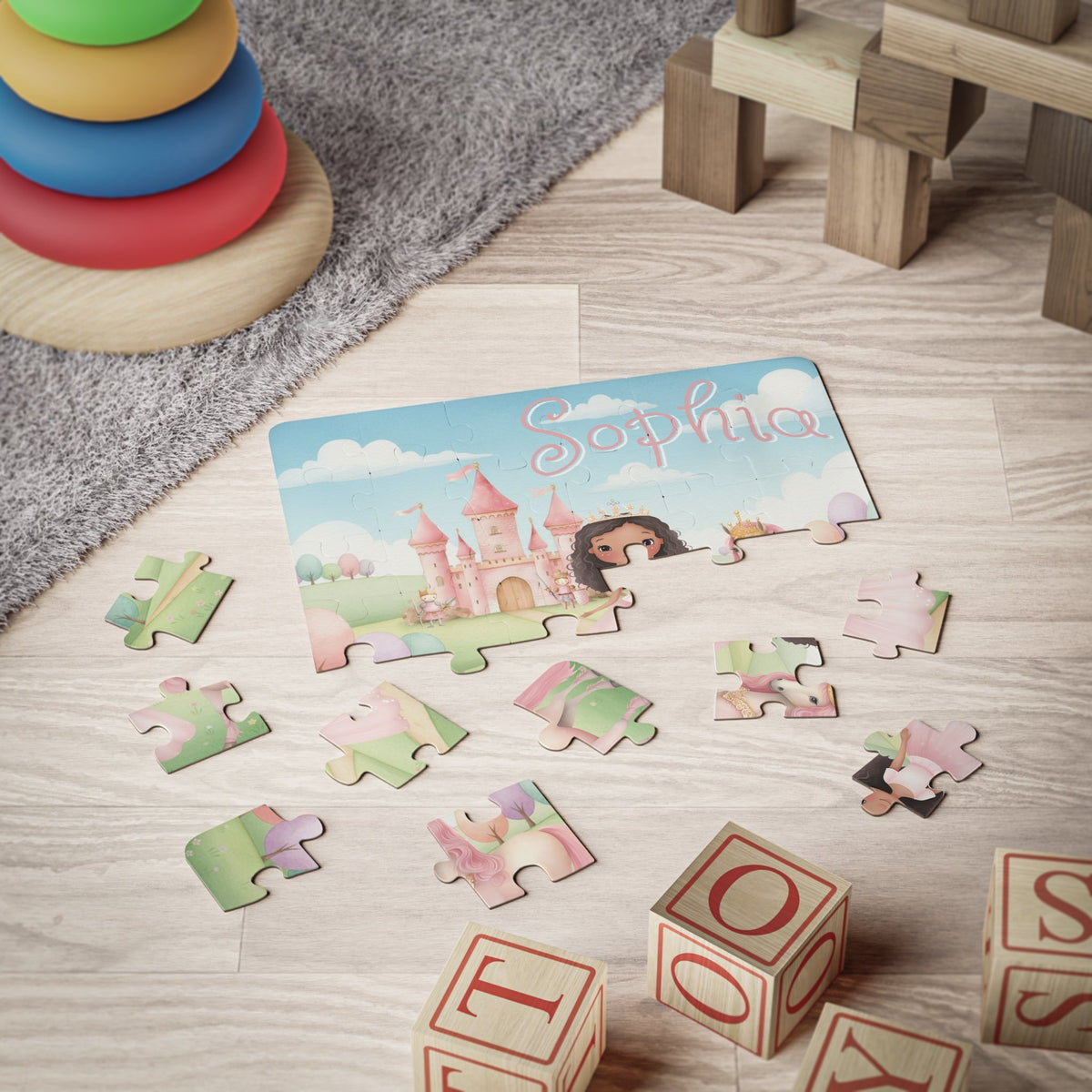 30-piece personalized princess puzzle shown partially assembled on the floor with loose jigsaw pieces, displaying a custom name across the top of the castle scene