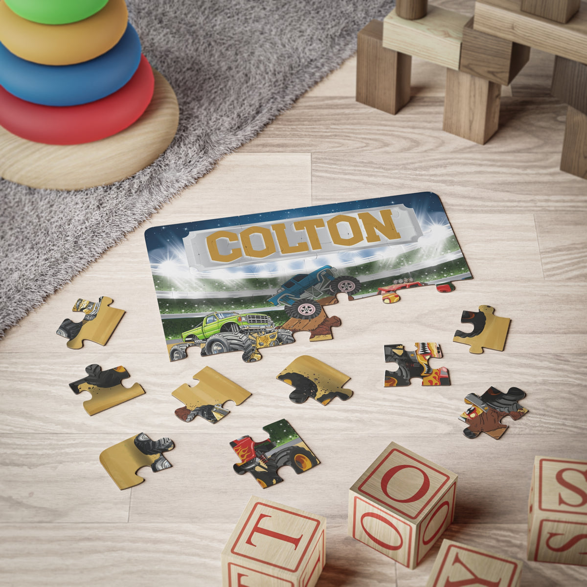 Completed 30-piece monster truck puzzle with customizable name across the top, featuring bright arena scene and larger pieces designed for beginner puzzle builders.