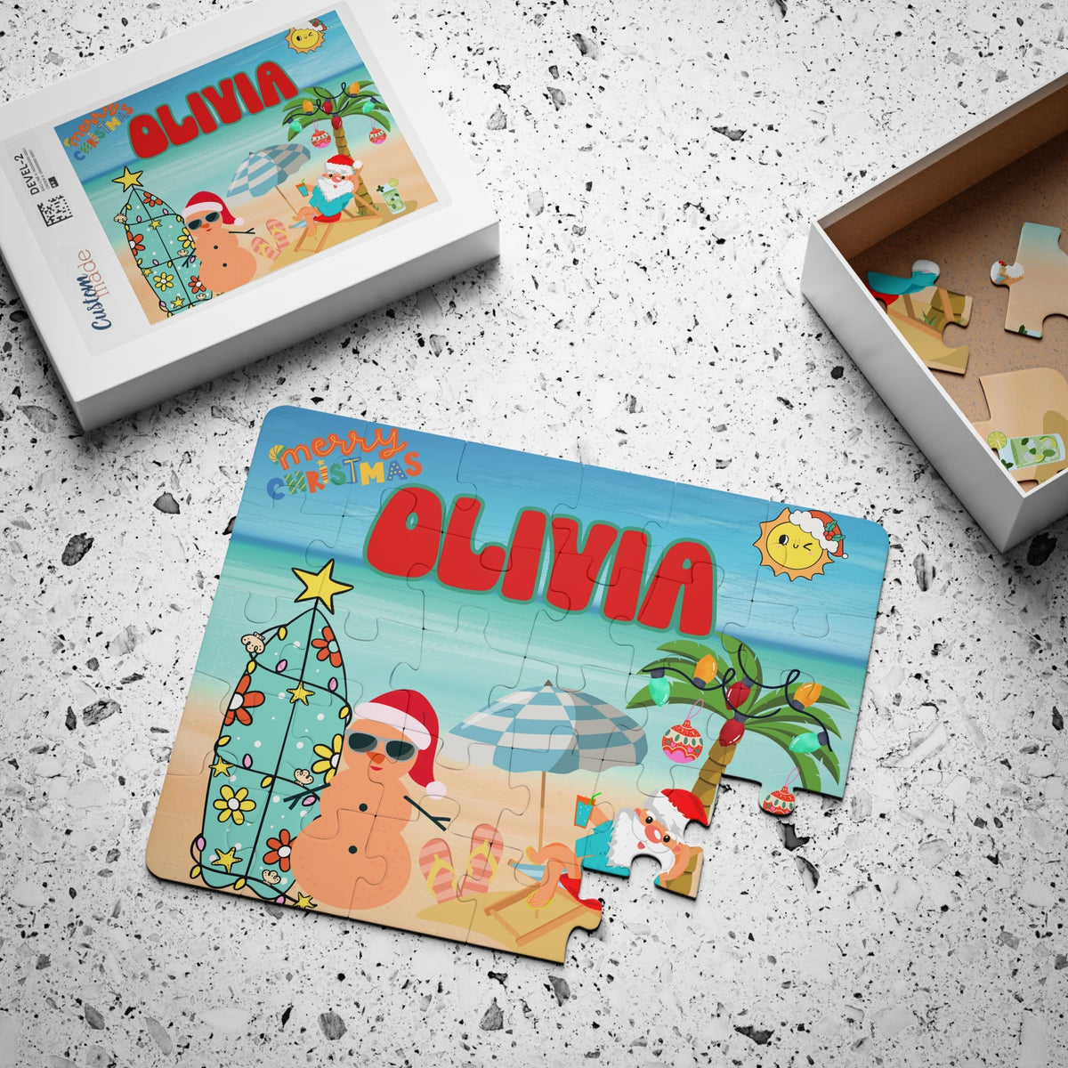 Personalized beach Christmas kids puzzle shown partially assembled next to its matching white puzzle box. The design features Santa relaxing at the beach with palm trees and tropical holiday decorations. The puzzle includes a customizable name printed across the top and is a 30-piece jigsaw designed for children.