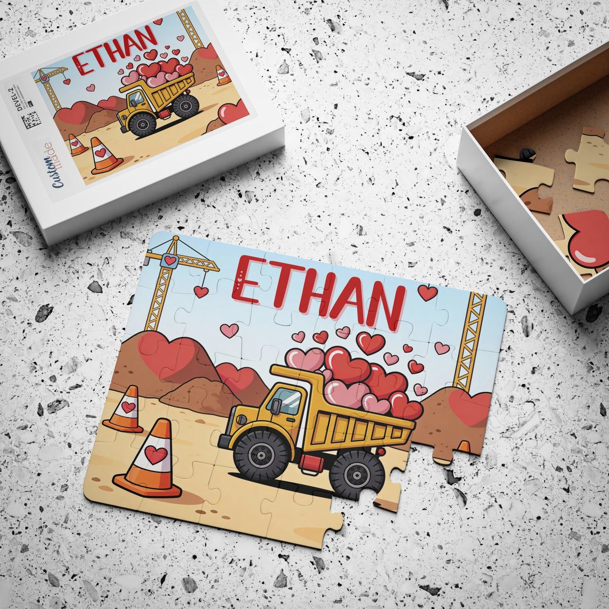 Personalized construction truck Valentine’s Day jigsaw puzzle with a customizable child’s name printed across the top, shown with the matching puzzle box and loose jigsaw pieces.