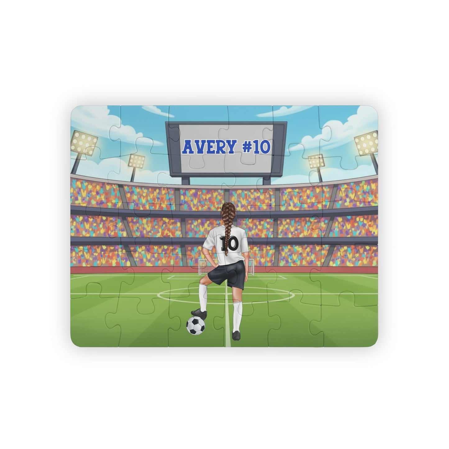 Personalized girls soccer puzzle showing a young player standing on a soccer field inside a large stadium, resting one foot on a soccer ball. The back of the jersey displays a customizable name and number, and a stadium scoreboard above also shows the personalized name and number.