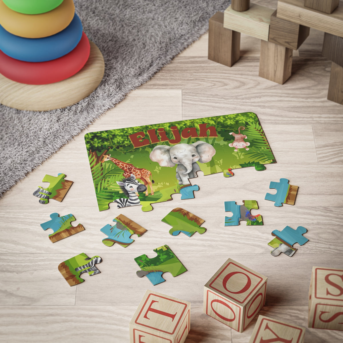 Personalized 30-piece jungle animal jigsaw puzzle shown partially assembled on the floor, with the child’s custom name displayed across the top and individual jigsaw pieces scattered around.