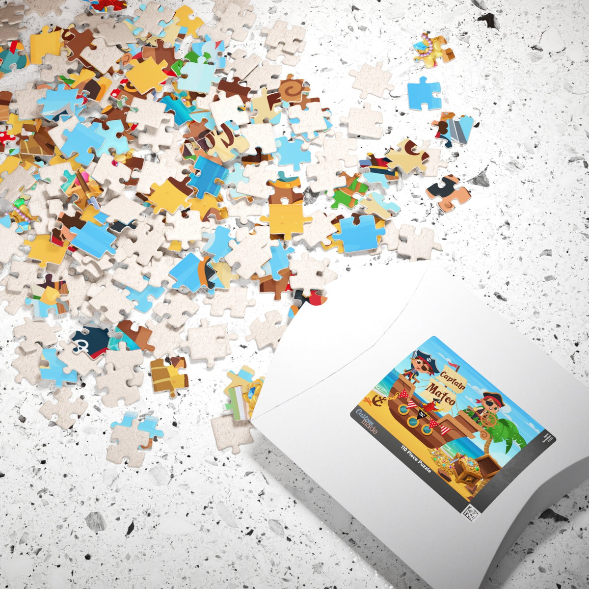 110-piece personalized jigsaw puzzle shown with loose pieces and branded puzzle box. The puzzle design features a pirate ship adventure scene, and the puzzle includes a customizable name printed on the artwork.