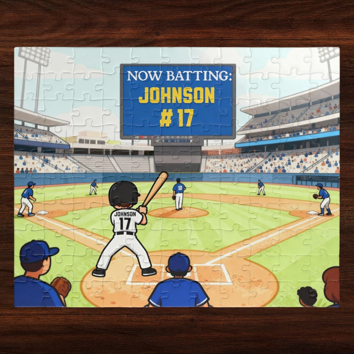 Personalized baseball puzzle for kids featuring a custom player name and jersey number on a large stadium scoreboard, with a cartoon batter at home plate and a full baseball field scene in the background.