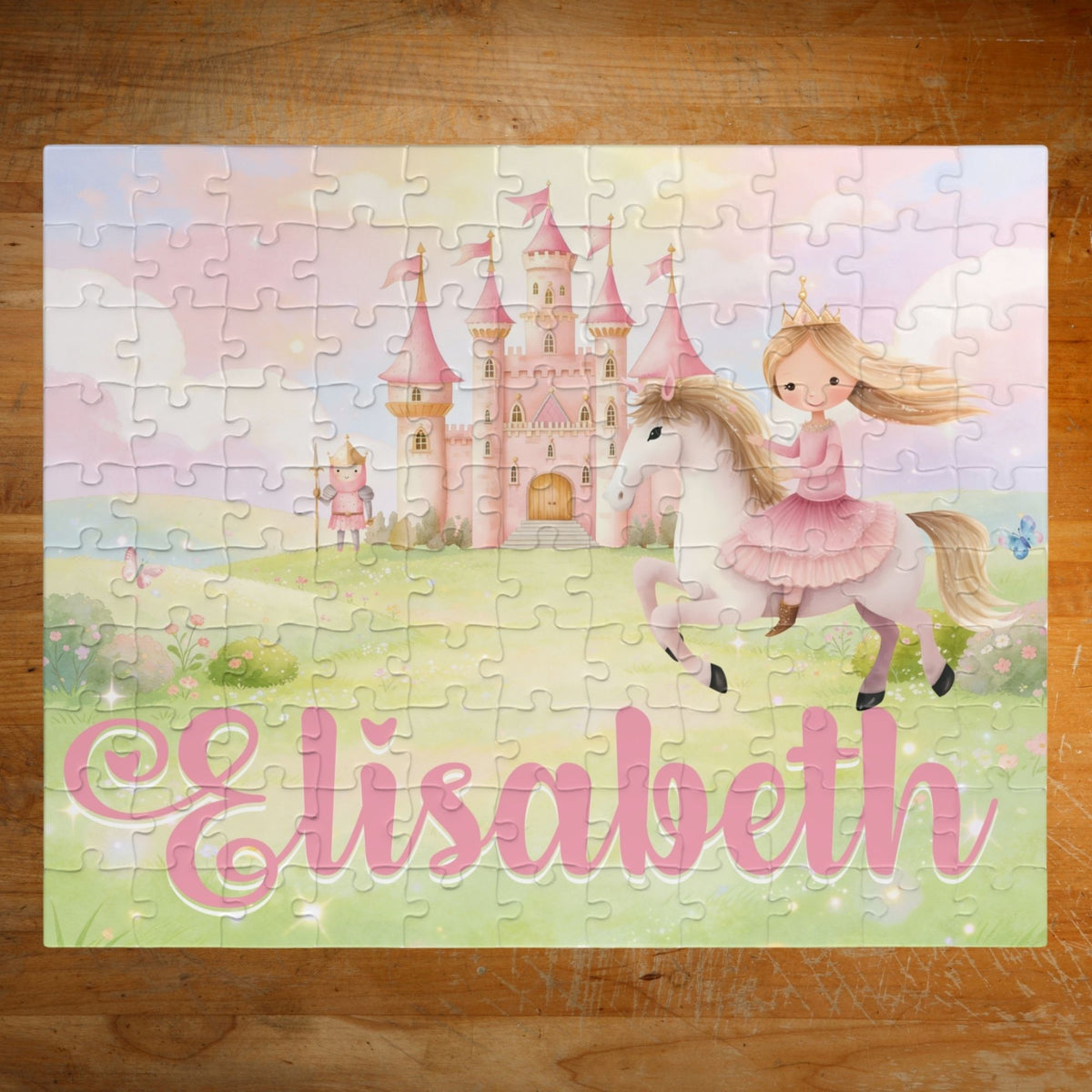 Completed personalized princess puzzle featuring a soft pastel fairytale scene with a princess on horseback, pink castle, flowers, sky, and a customizable child’s name displayed across the bottom.