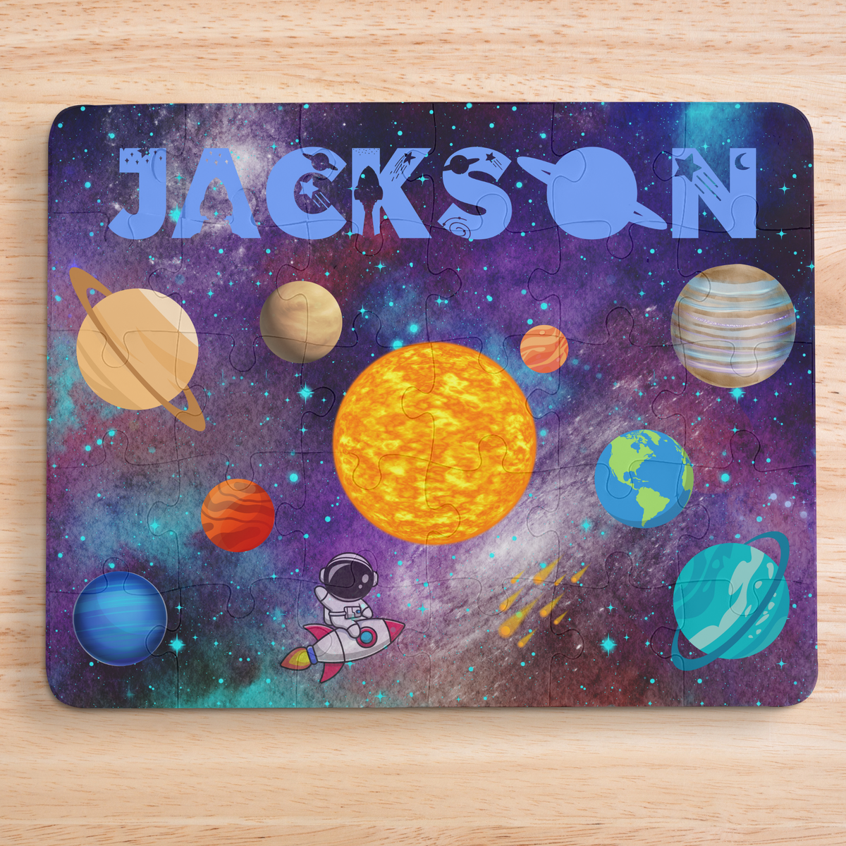 Personalized kids space puzzle featuring a colorful solar system scene with planets, stars, and an astronaut, customized with the child’s name at the top in large blue letters. Educational jigsaw puzzle designed for young children to learn about space and planets.