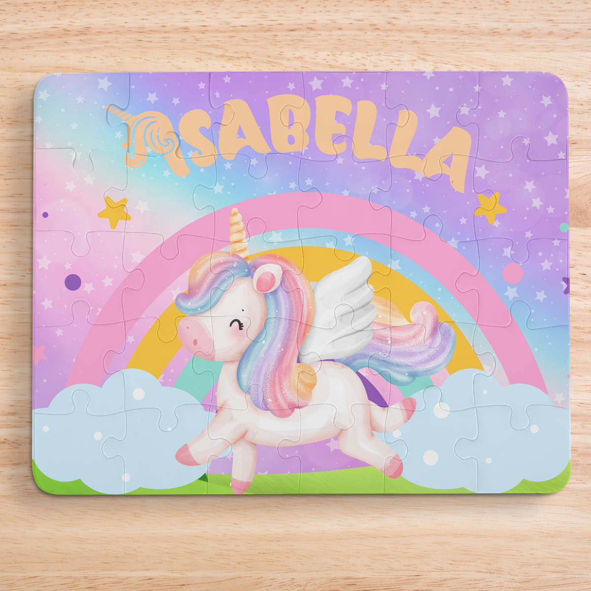 Personalized unicorn-themed kids jigsaw puzzle with a customizable name displayed across the top, featuring a pastel unicorn, rainbow, clouds, and stars on a colorful background.