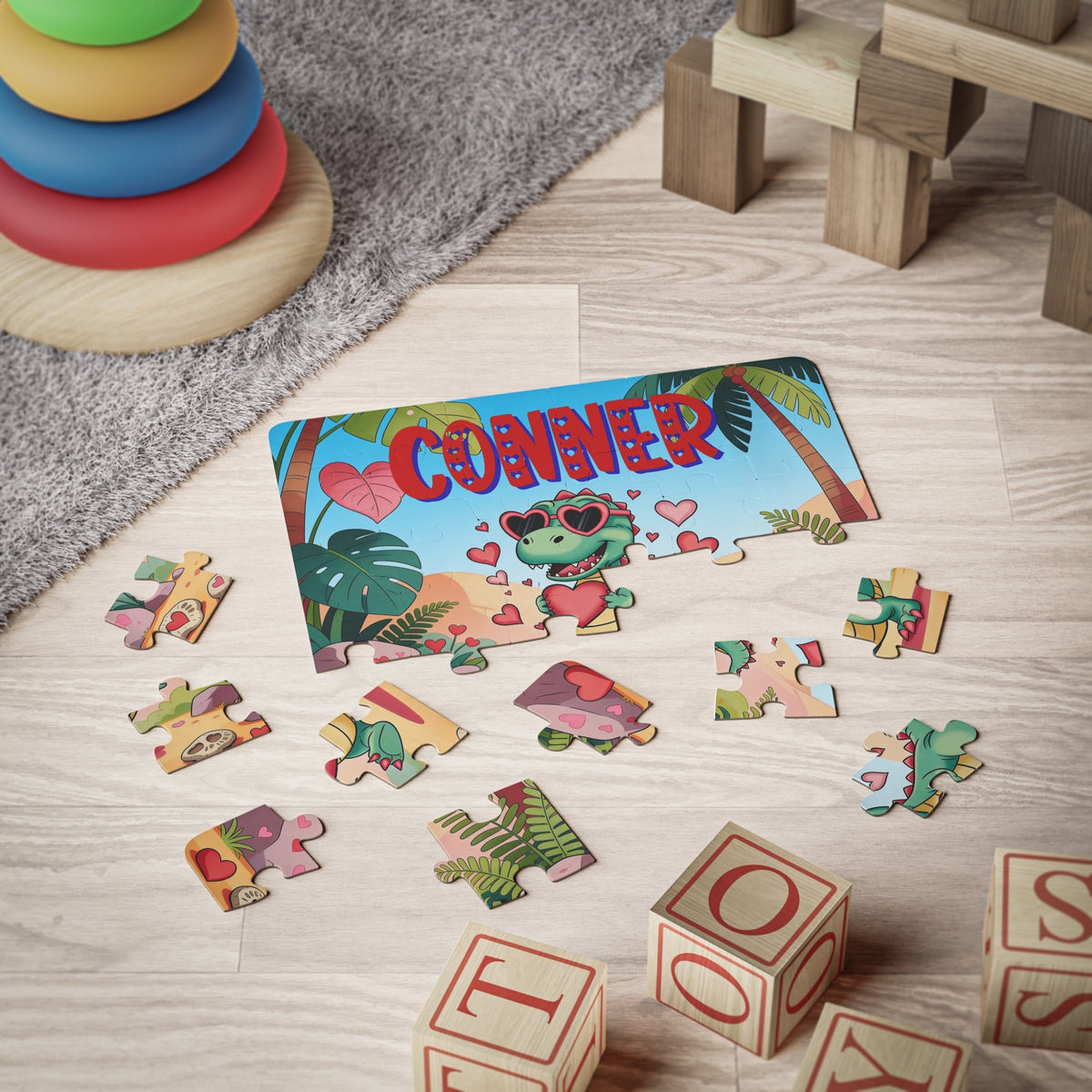 Personalized kids jigsaw puzzle featuring a tropical dinosaur illustration with hearts and palm trees, shown partially assembled with scattered pieces. The puzzle includes a customizable name printed across the top of the design.