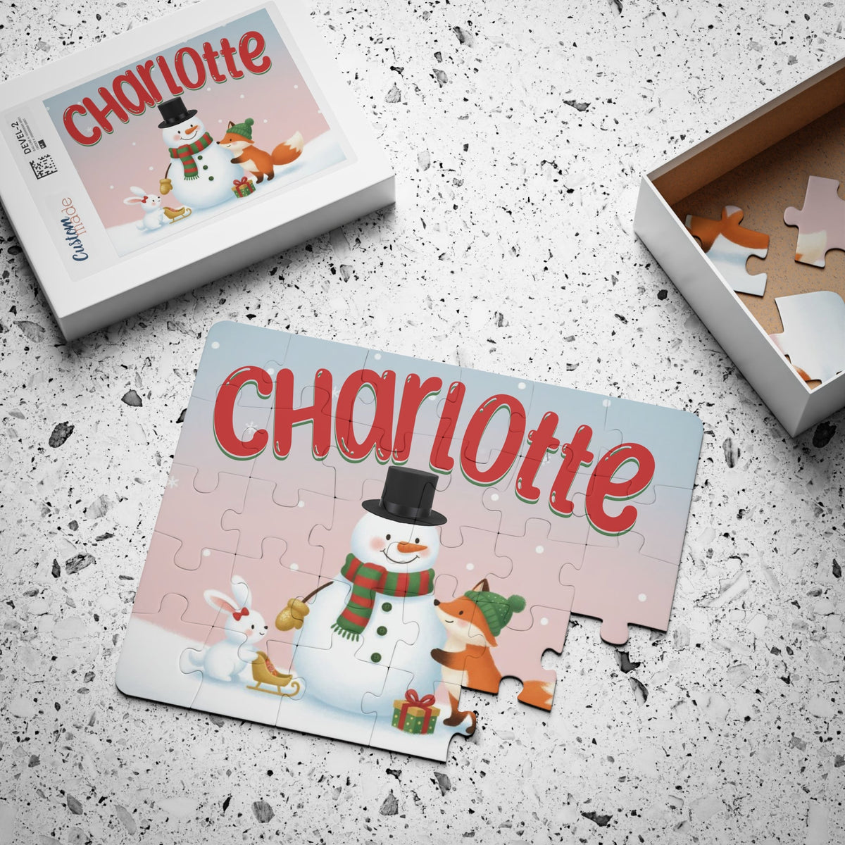 Personalized Christmas puzzle for kids displayed with its box, showing a snowman and animal friends winter design with the child’s custom name printed across the top of the puzzle.