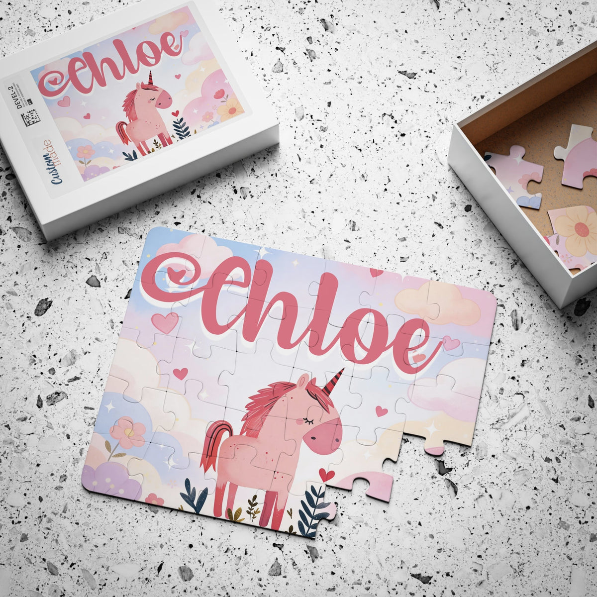 Personalized unicorn jigsaw puzzle with a child’s customizable name displayed across the top, shown next to the matching puzzle box that features the same design and name placement.