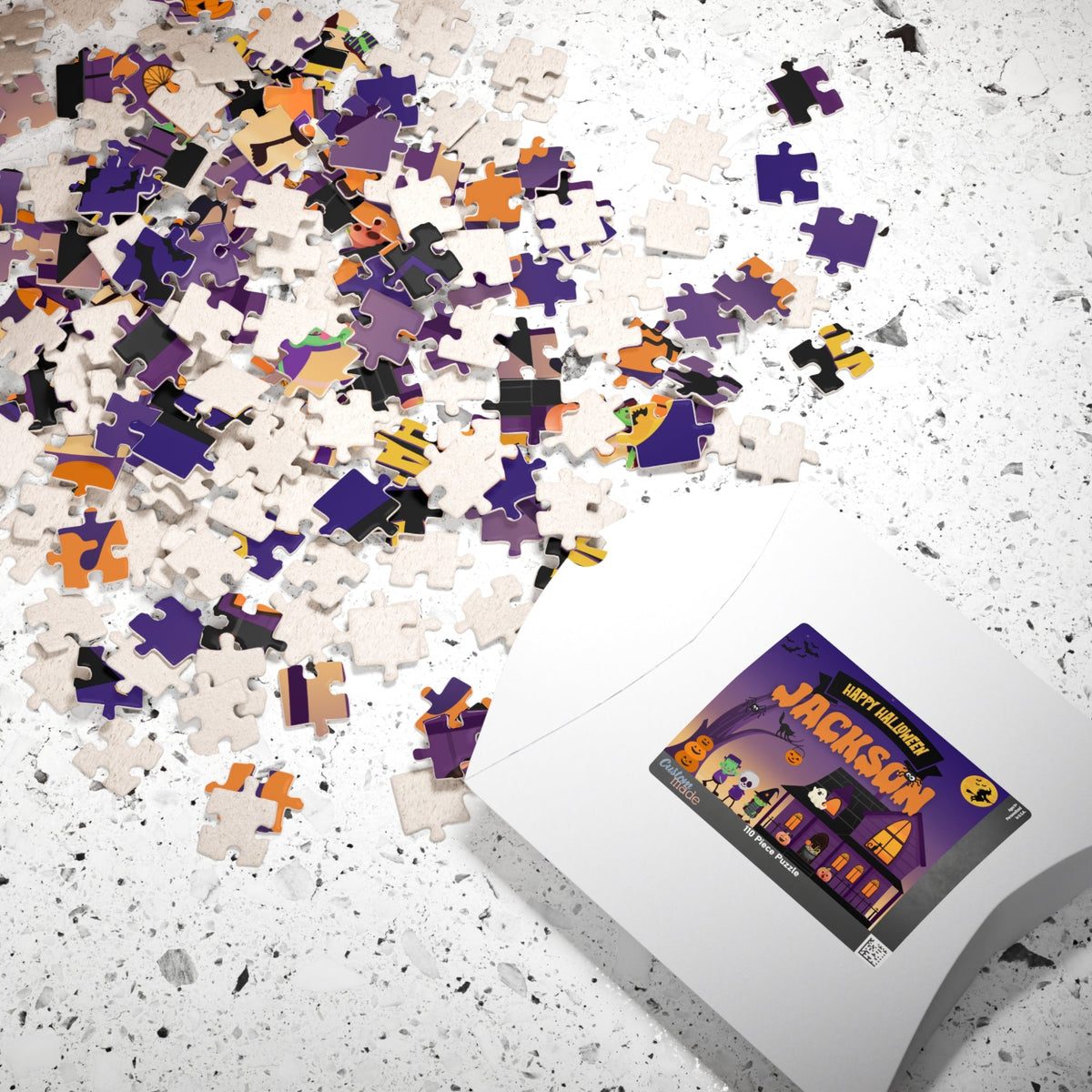 White puzzle box packaging for a personalized 110-piece Halloween kids jigsaw puzzle, displaying the haunted house trick-or-treat design on the label. The puzzle is customizable with the child’s name printed on the finished puzzle.