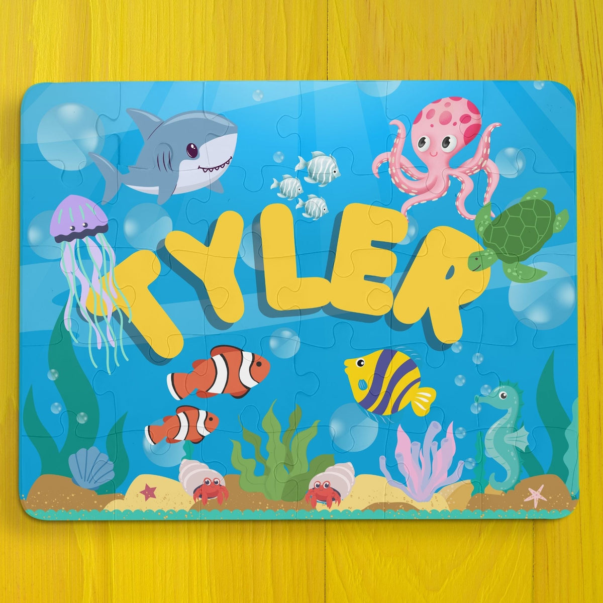 Personalized 30-piece ocean puzzle for kids featuring colorful underwater animals like sharks, octopus, jellyfish, fish, and turtles, with the child’s name displayed in large letters across the center