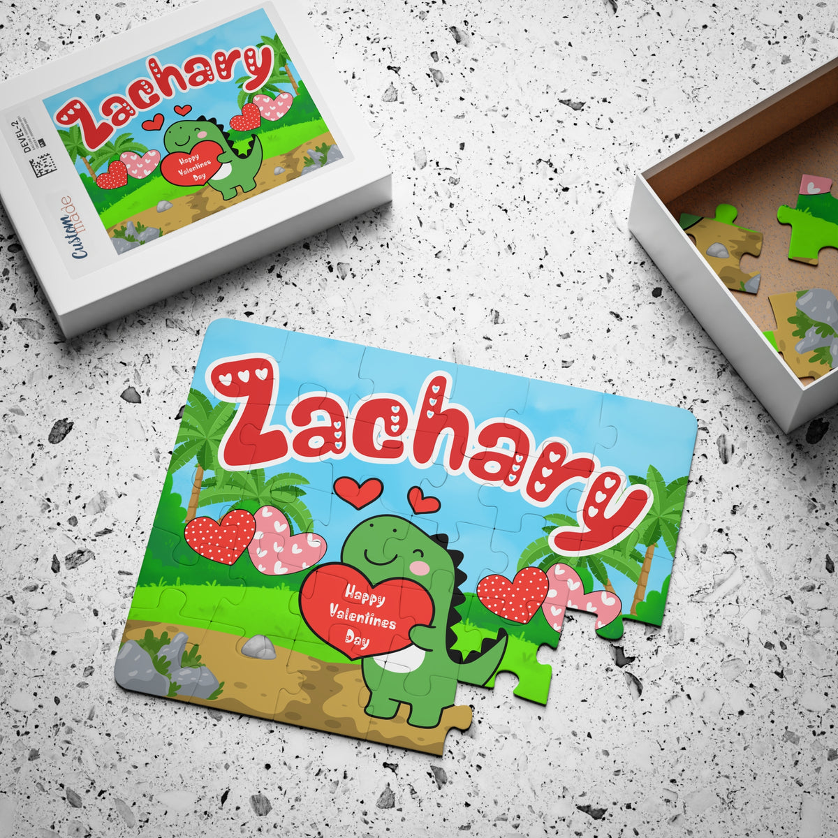 Custom dinosaur Valentine’s Day jigsaw puzzle with a personalized name displayed across the top of the design, shown alongside the matching puzzle box and loose pieces to highlight packaging, print quality, and piece size.
