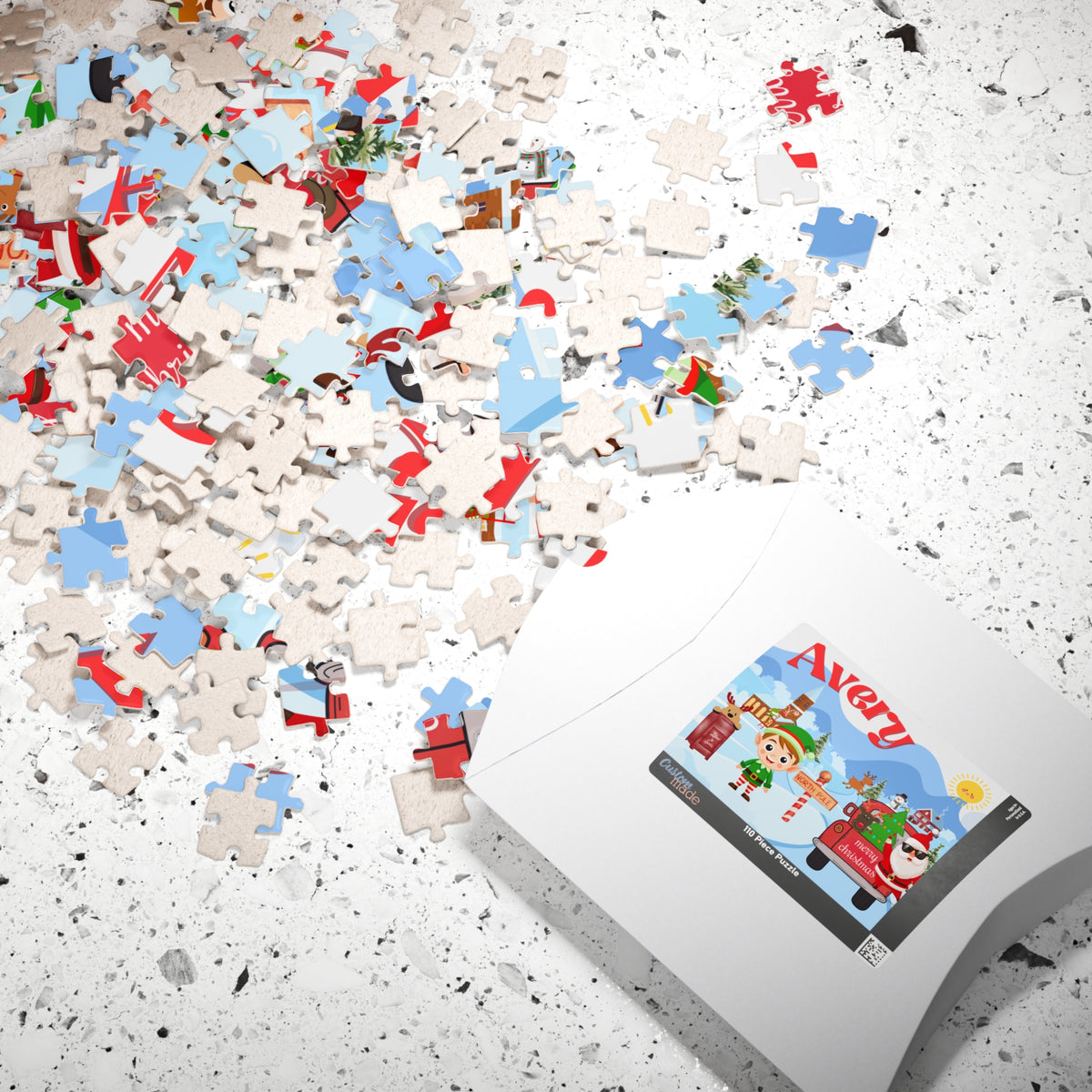 Personalized Christmas puzzle pieces scattered beside the puzzle box, featuring a festive North Pole design with Santa, an elf, reindeer, and a custom child's name.