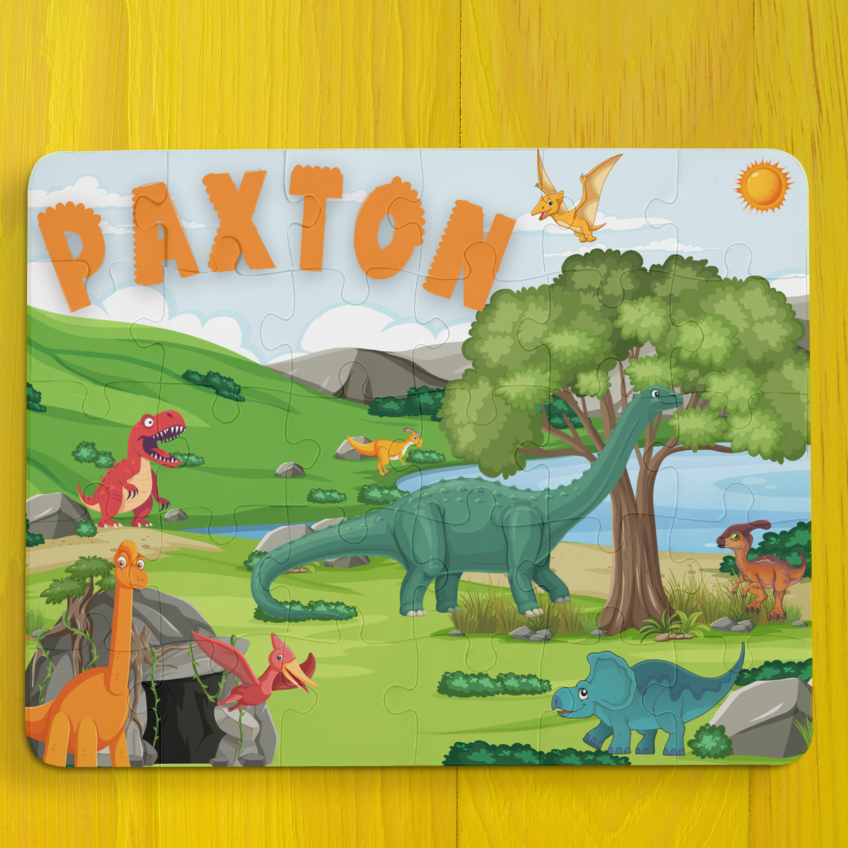 Personalized dinosaur name puzzle for kids featuring a colorful Jurassic scene with volcano, T-rex, palm trees, and friendly dinosaurs, custom child name displayed at the top, 30-piece educational jigsaw