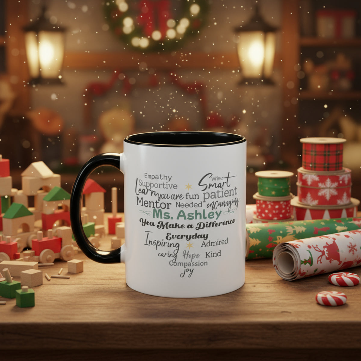 White ceramic accent mug with black handle and interior, displaying a heart-shaped word cloud design with a customizable name centered in the design. Mug is styled on a wooden table with holiday decor, gift wrap, and festive accents. Available in 11oz and 15oz sizes.