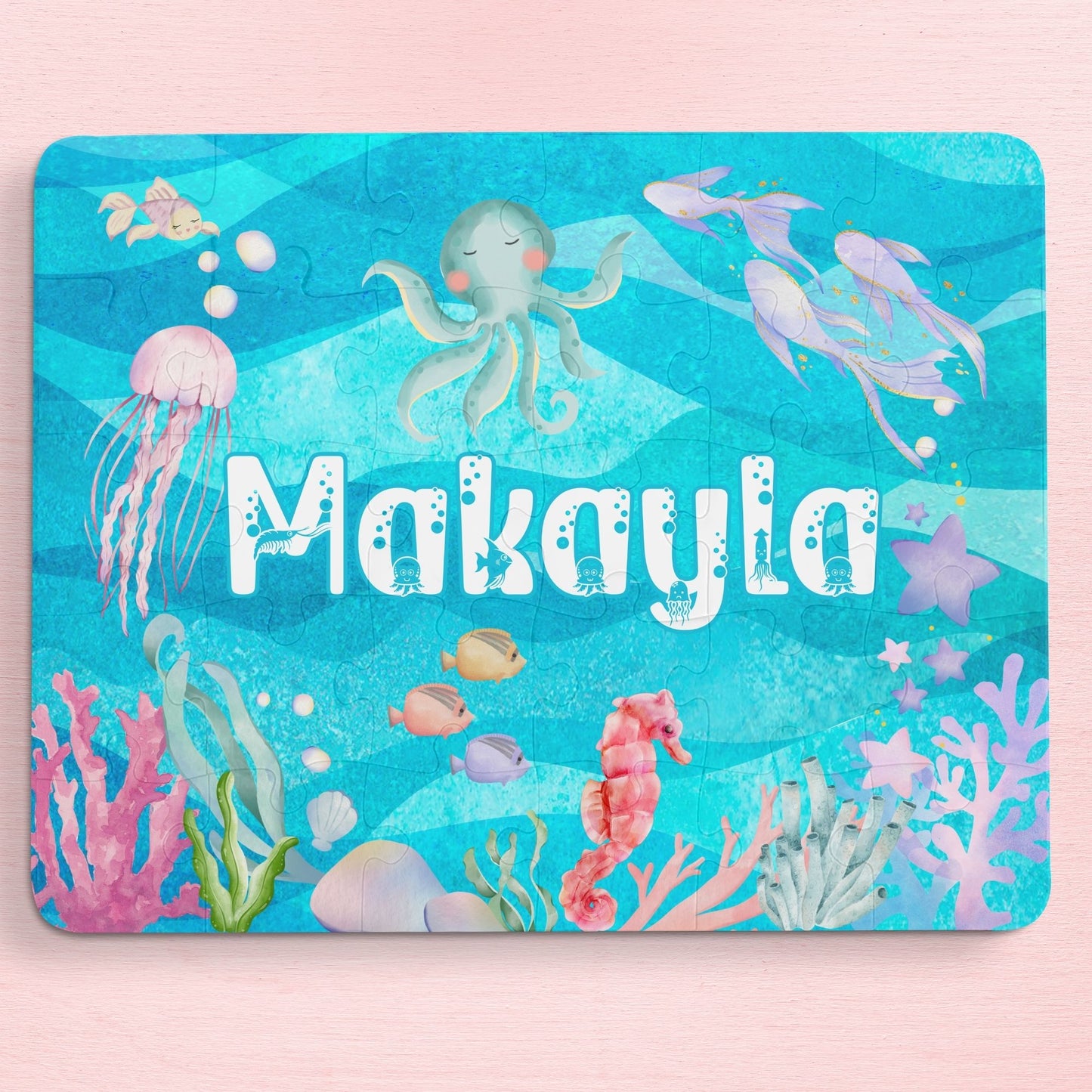 Personalized 30-piece ocean puzzle for kids featuring a colorful under-the-sea scene with an octopus, jellyfish, fish, coral, and bubbles, customized with the child’s name in large playful letters.