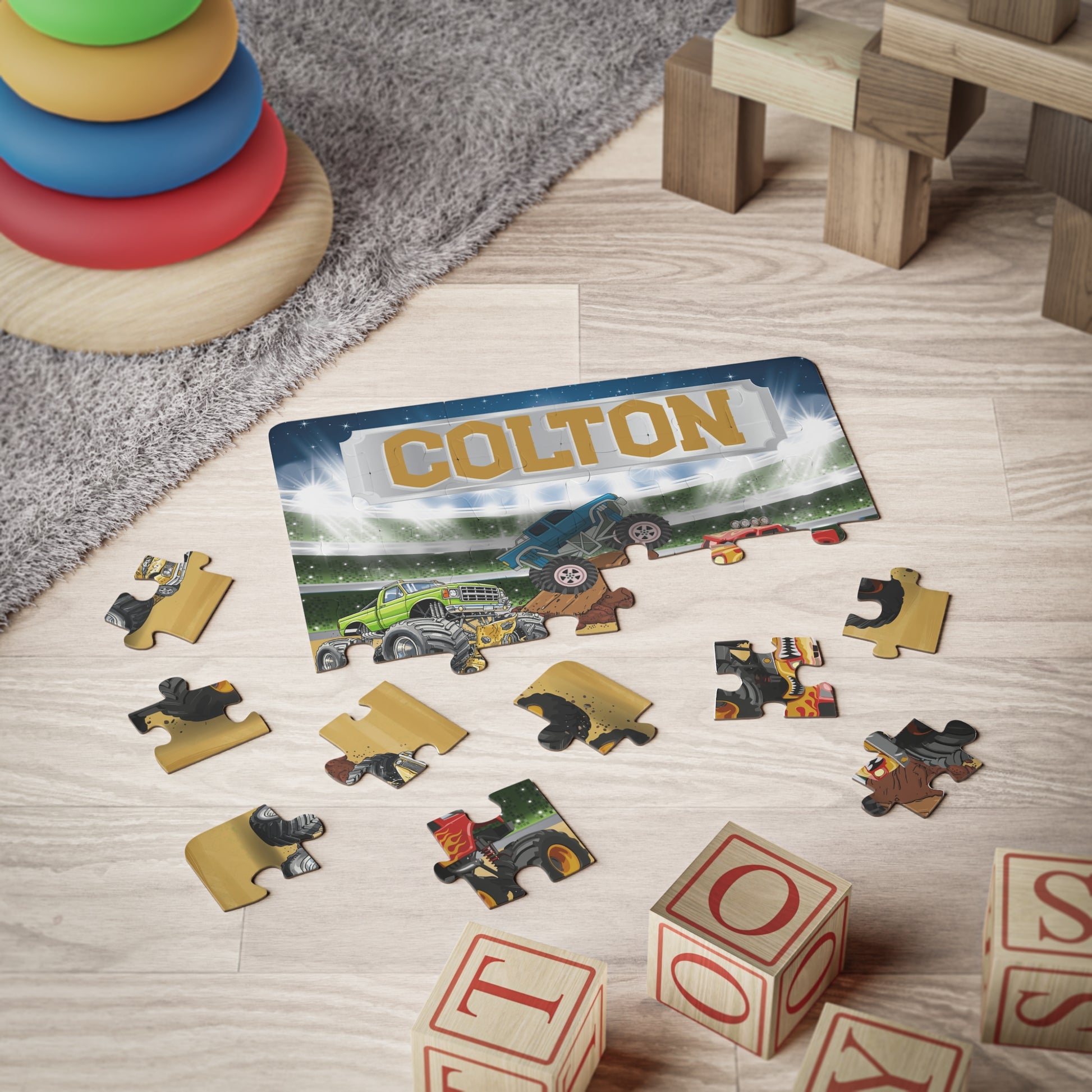 Completed 30-piece monster truck puzzle with customizable name across the top, featuring bright arena scene and larger pieces designed for beginner puzzle builders.