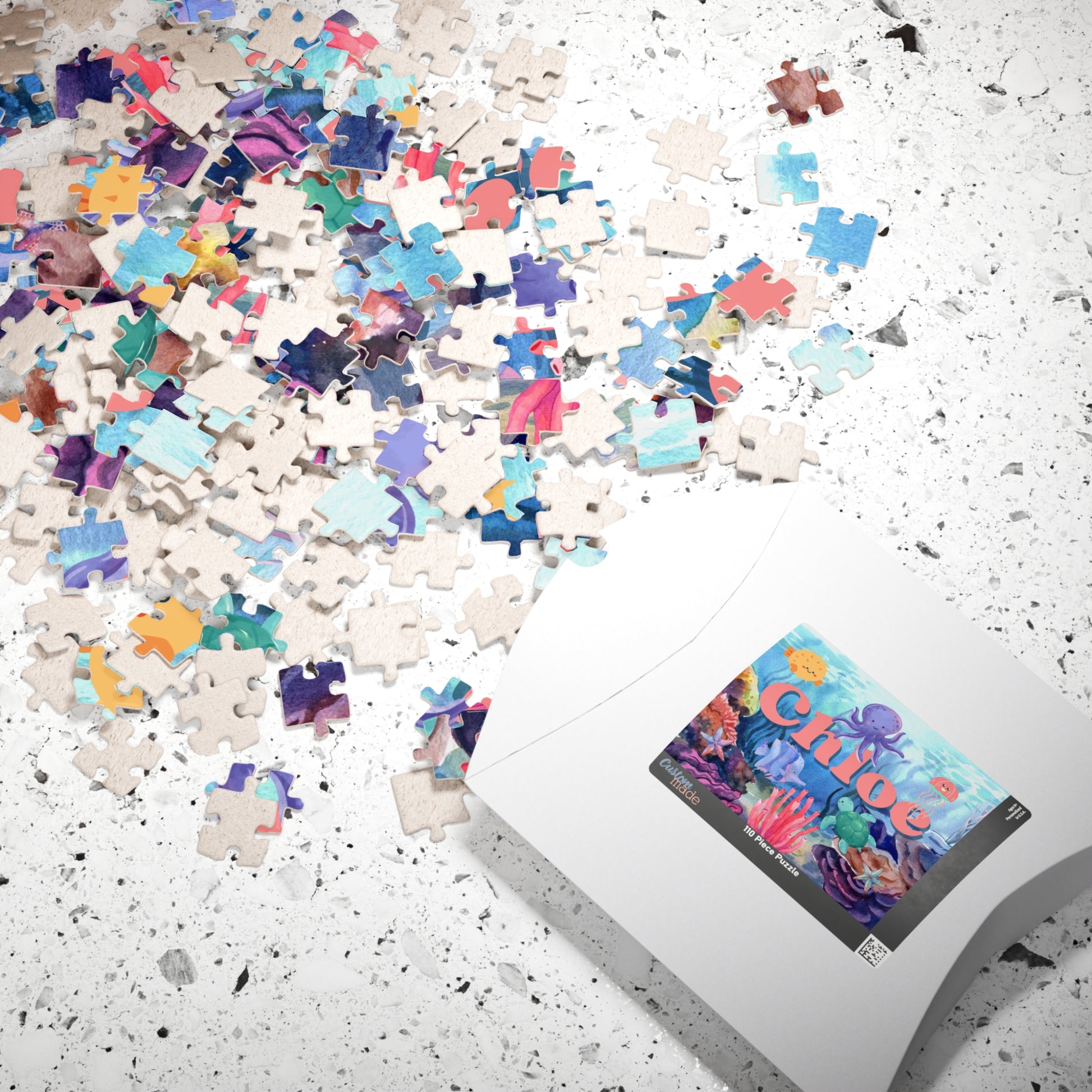 Personalized ocean-themed 110-piece jigsaw puzzle displayed with scattered jigsaw pieces and the puzzle box. Features a vibrant underwater scene and a customizable name printed within the design.