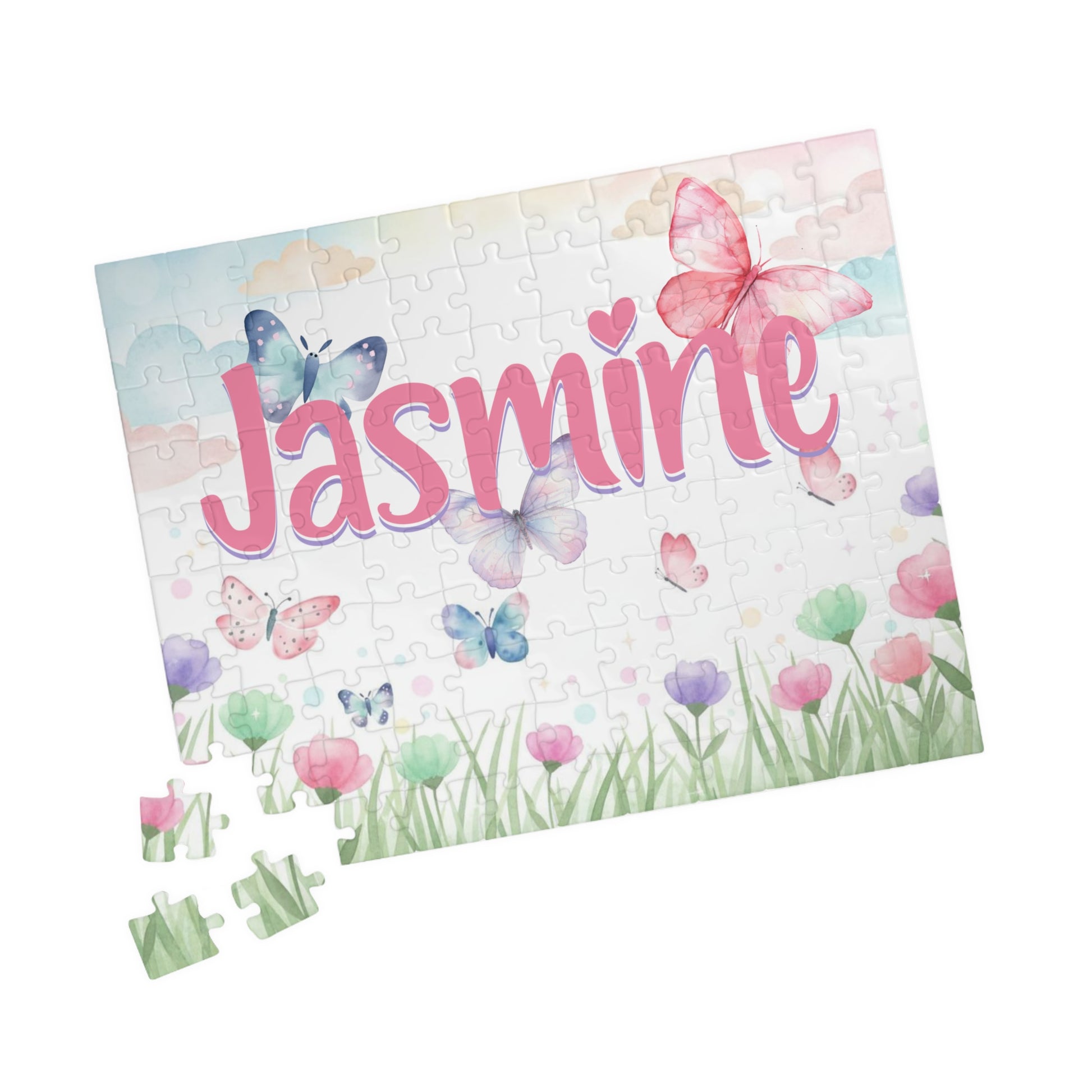 Personalized butterfly meadow 110-piece jigsaw puzzle shown at an angle with a few loose jigsaw pieces nearby. The spring-themed design includes flowers, butterflies, and a custom name integrated into the artwork.