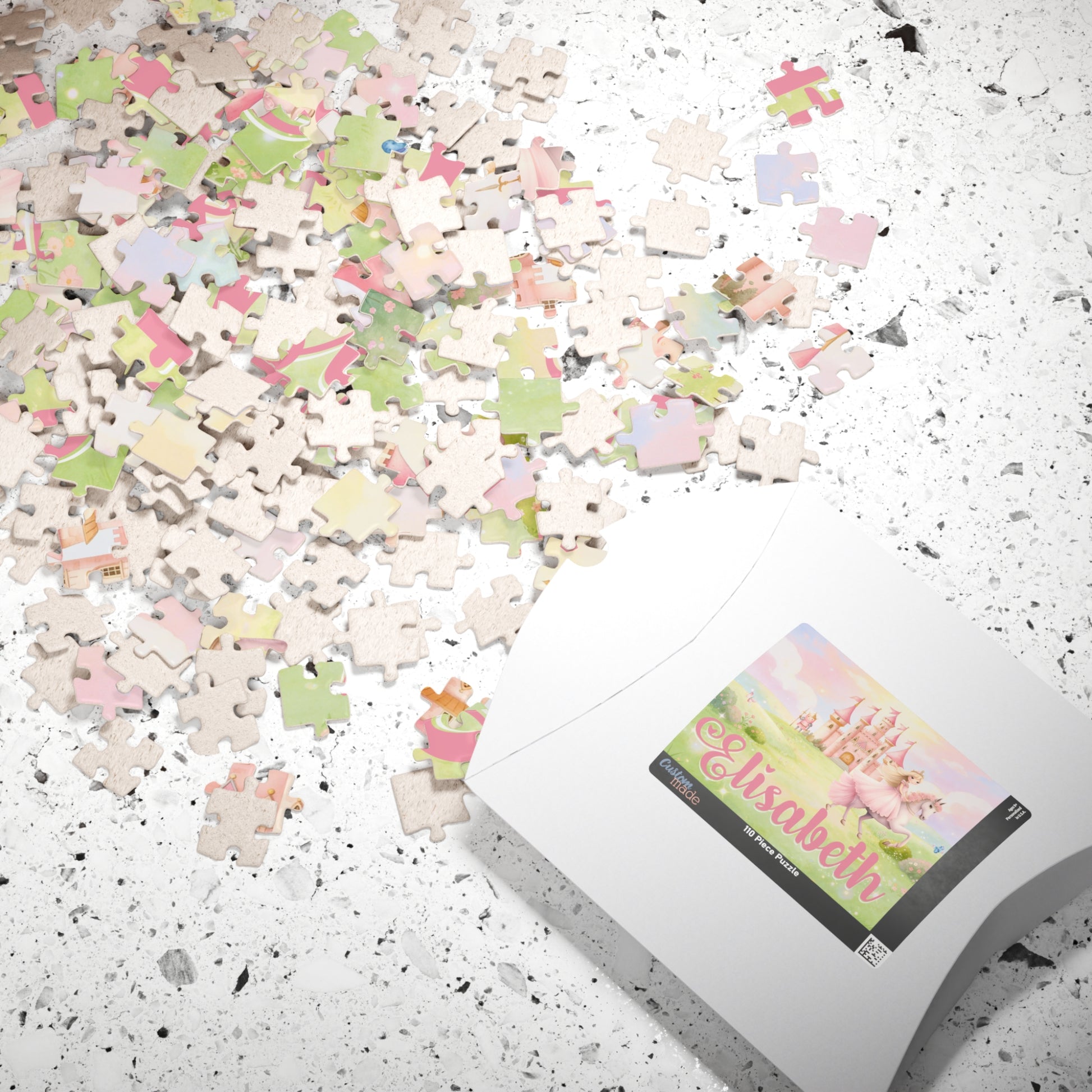 Scattered jigsaw puzzle pieces on a surface beside packaging displaying a pastel princess puzzle with castle, horse, soft landscape, and a customizable child’s name on the box label.
