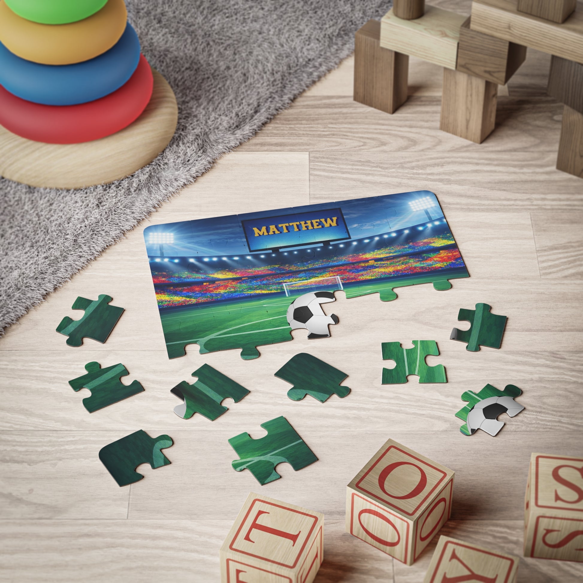 Custom soccer puzzle displayed during playtime with scattered jigsaw pieces, highlighting the personalized name on the stadium screen and soccer ball. 30-piece kids jigsaw.