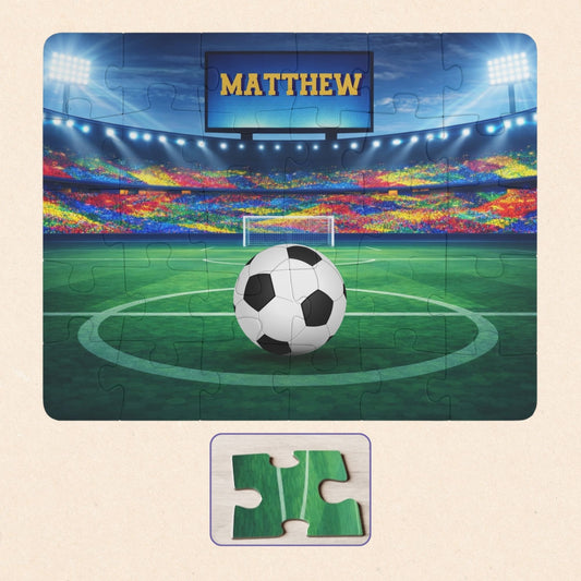 Personalized soccer stadium puzzle shown as a 30-piece jigsaw with a bright field, cheering crowd, and scoreboard displaying a customizable name. Soccer ball features selectable color options.