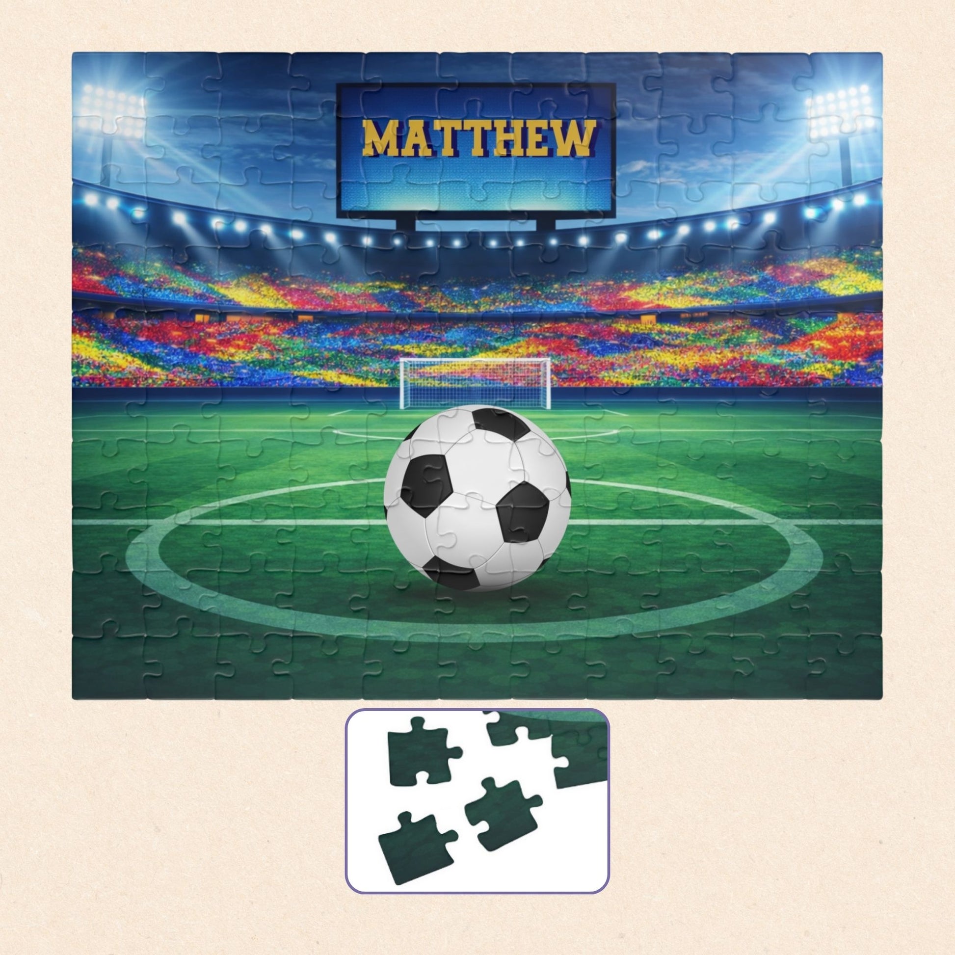 Fully assembled personalized soccer stadium jigsaw puzzle with a close-up inset showing individual jigsaw pieces. Customizable name is displayed on the stadium screen above the field. 110-piece puzzle design.