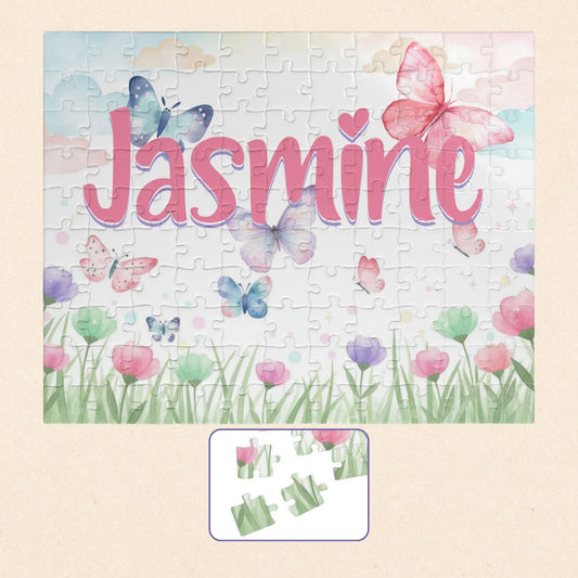Personalized spring butterfly meadow 110-piece jigsaw puzzle featuring soft pastel flowers, grass, and fluttering butterflies. A customizable name appears prominently across the center of the puzzle design.