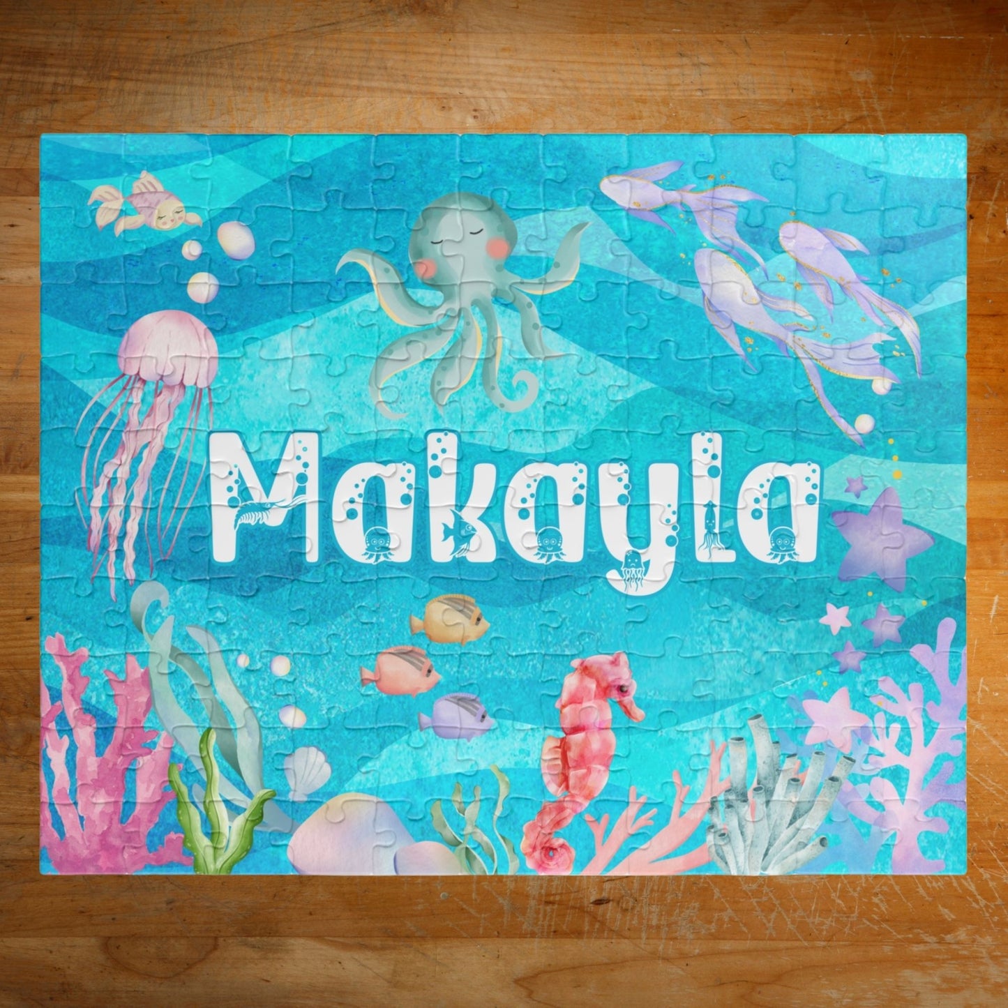 Personalized 110 piece ocean themed jigsaw puzzle featuring a customizable name centered in an underwater scene with sea animals, coral, and bubbles