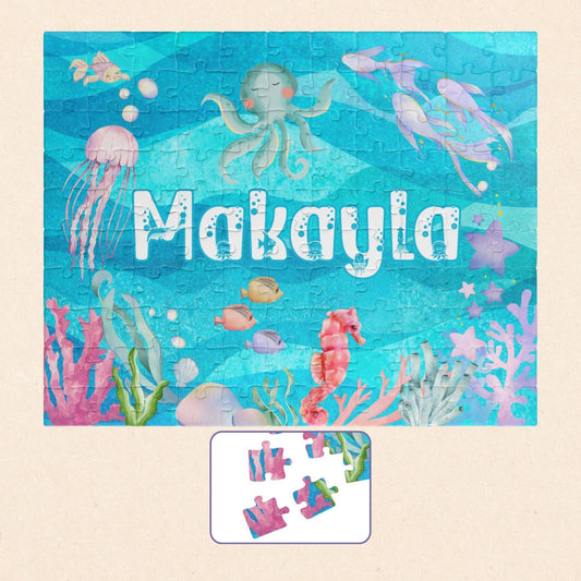 Personalized 110 piece ocean themed jigsaw puzzle featuring a customizable name centered in an underwater scene with sea animals, coral, and bubbles