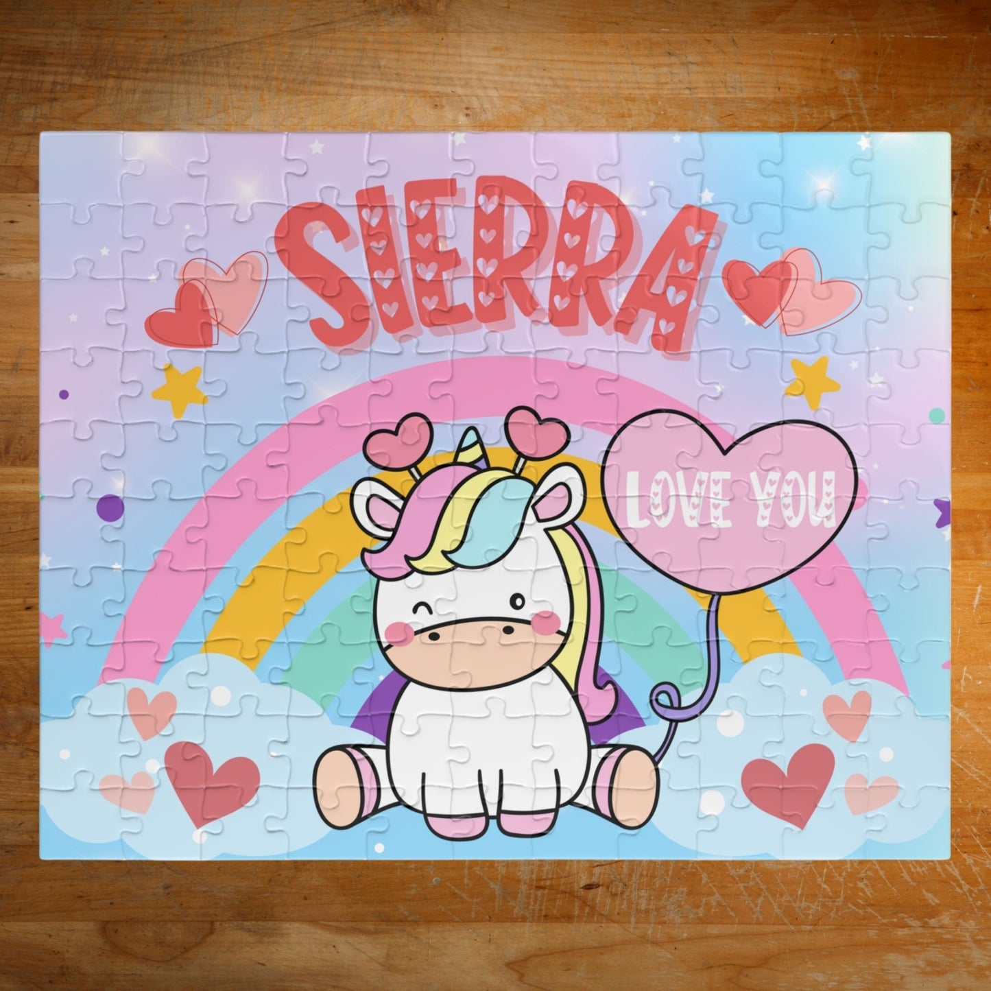 Personalized 110-piece unicorn rainbow puzzle with rainbow arch, heart balloon, pastel sky, and customizable child’s name prominently displayed.
