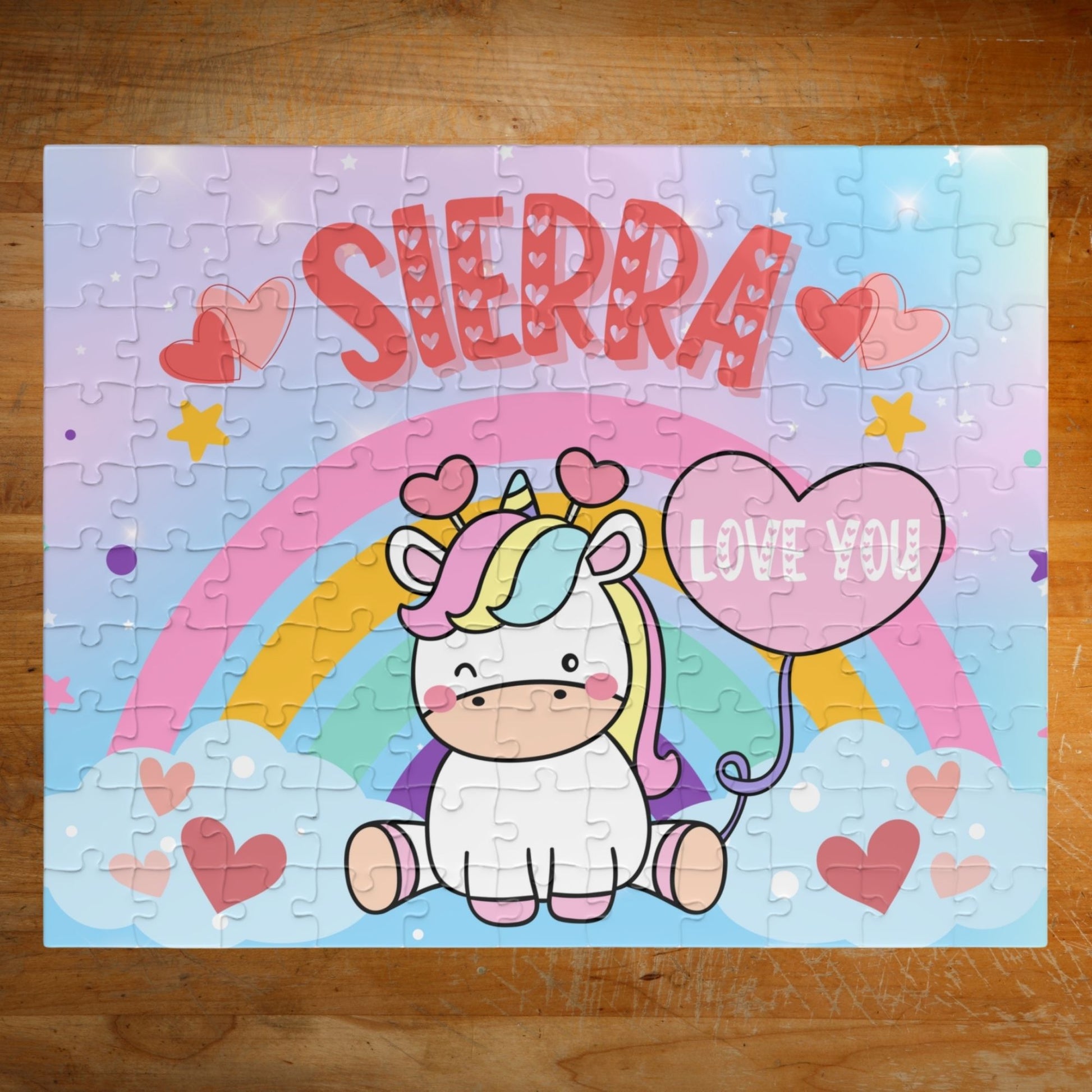 Personalized 110-piece unicorn rainbow puzzle with rainbow arch, heart balloon, pastel sky, and customizable child’s name prominently displayed.