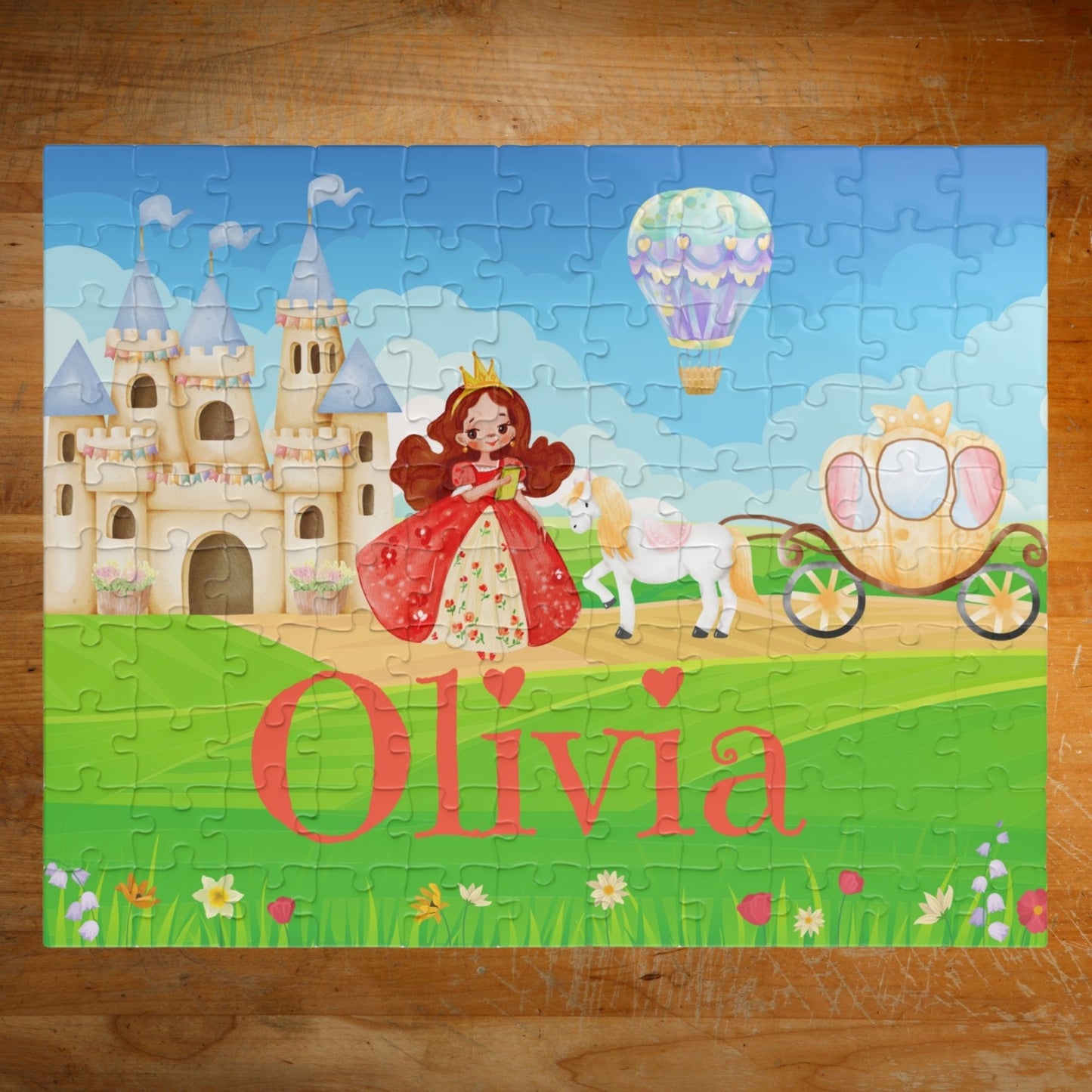 Completed personalized princess puzzle featuring a fairytale castle, princess character, horse, royal carriage, hot air balloon, bright sky, and a customizable child’s name across the grass.