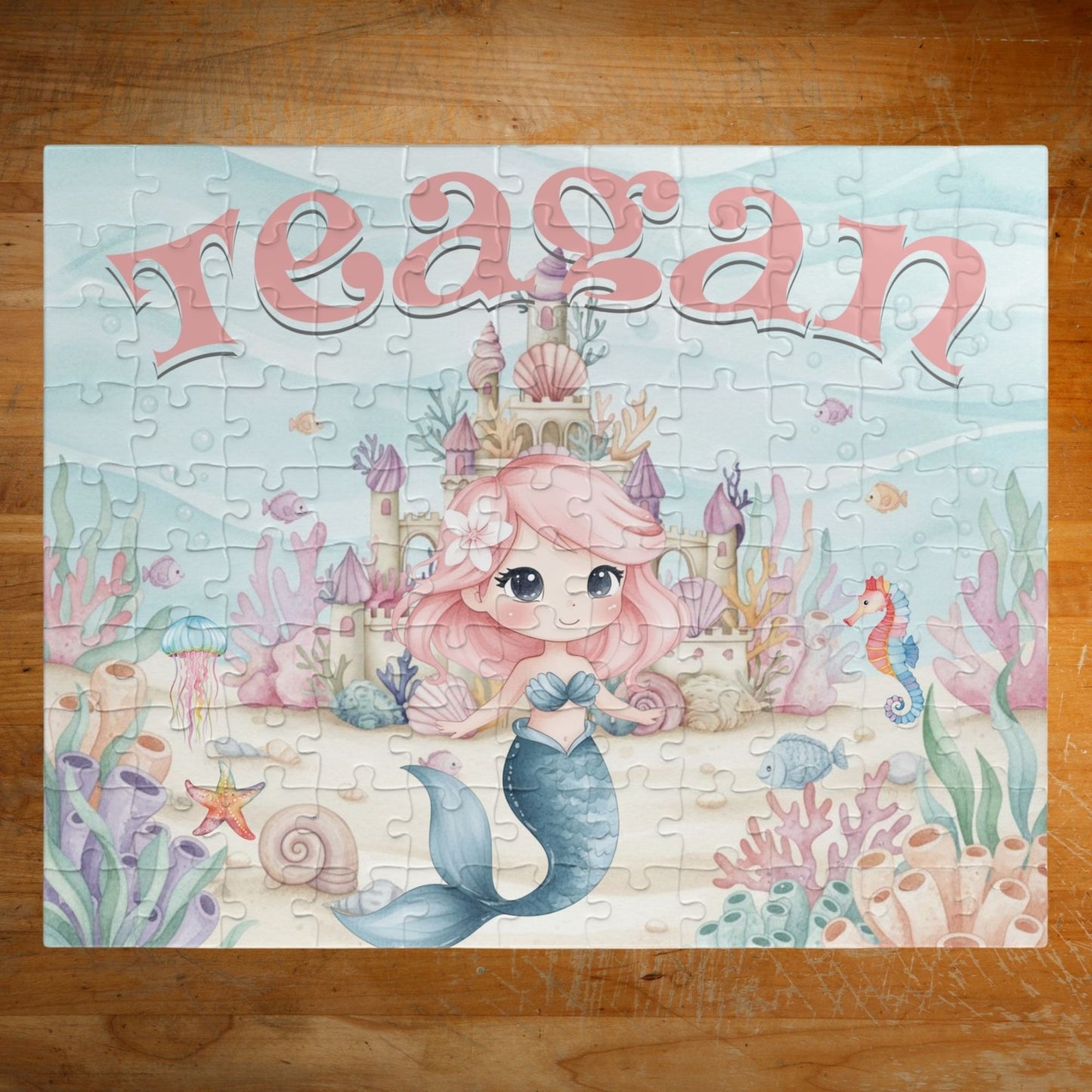 Completed personalized mermaid puzzle featuring an underwater ocean scene with a mermaid, coral, seashells, seahorse, fish, castle, and a customizable child’s name displayed prominently at the top.