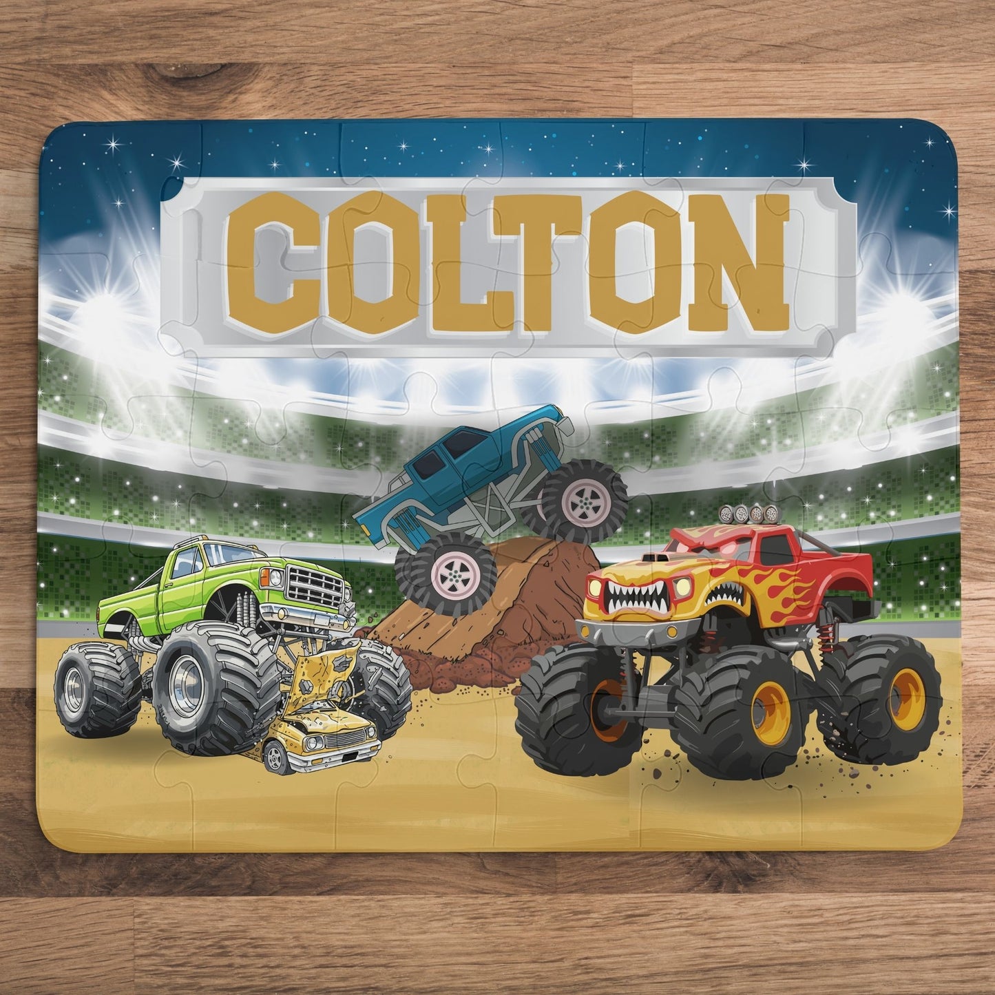 Personalized monster truck puzzle with customizable name displayed across the top, featuring a colorful stadium scene and larger pieces designed for small hands.