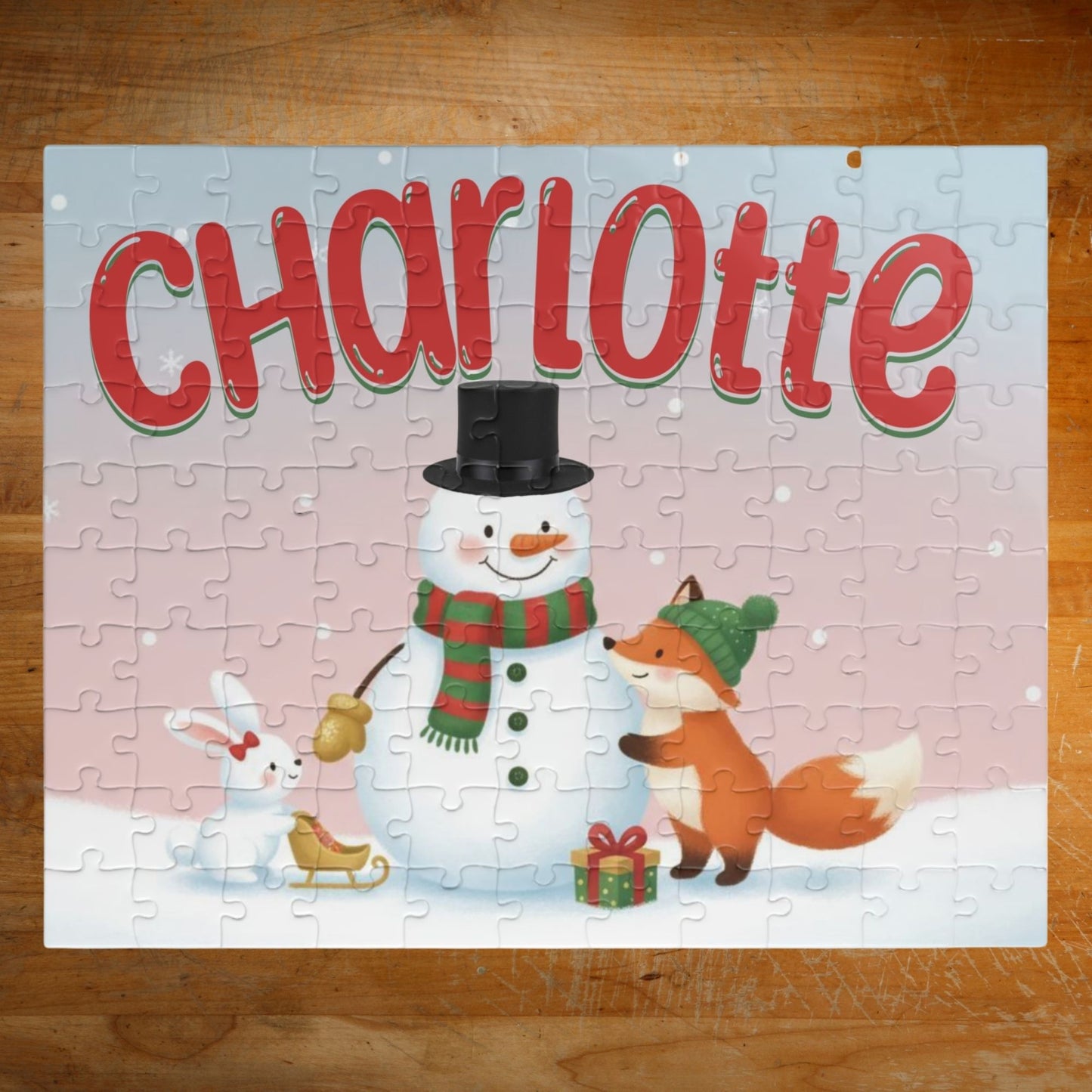 Personalized 110-piece Christmas puzzle featuring a custom name with a smiling snowman, fox, and bunny in a snowy winter scene.