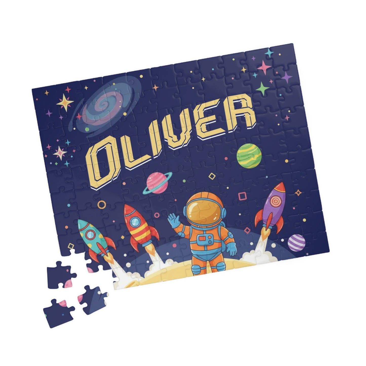Close-up of scattered 110 piece space astronaut puzzle pieces showing colorful rockets, planets, and galaxy artwork from a personalized name puzzle