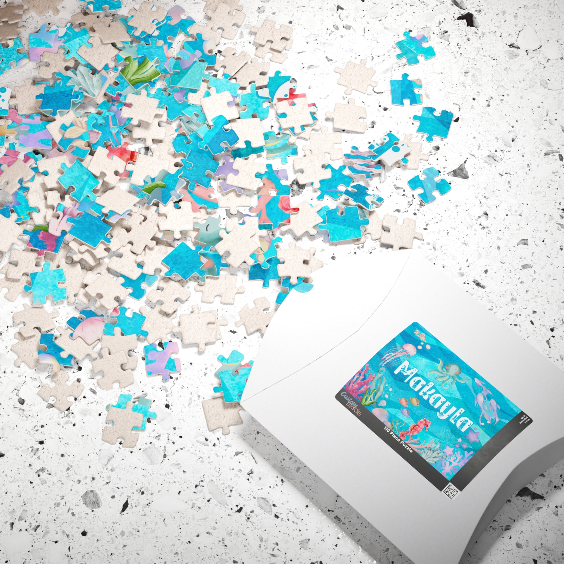 Personalized 110 piece ocean name jigsaw puzzle shown with matching puzzle box, featuring a customizable name and soft watercolor underwater design