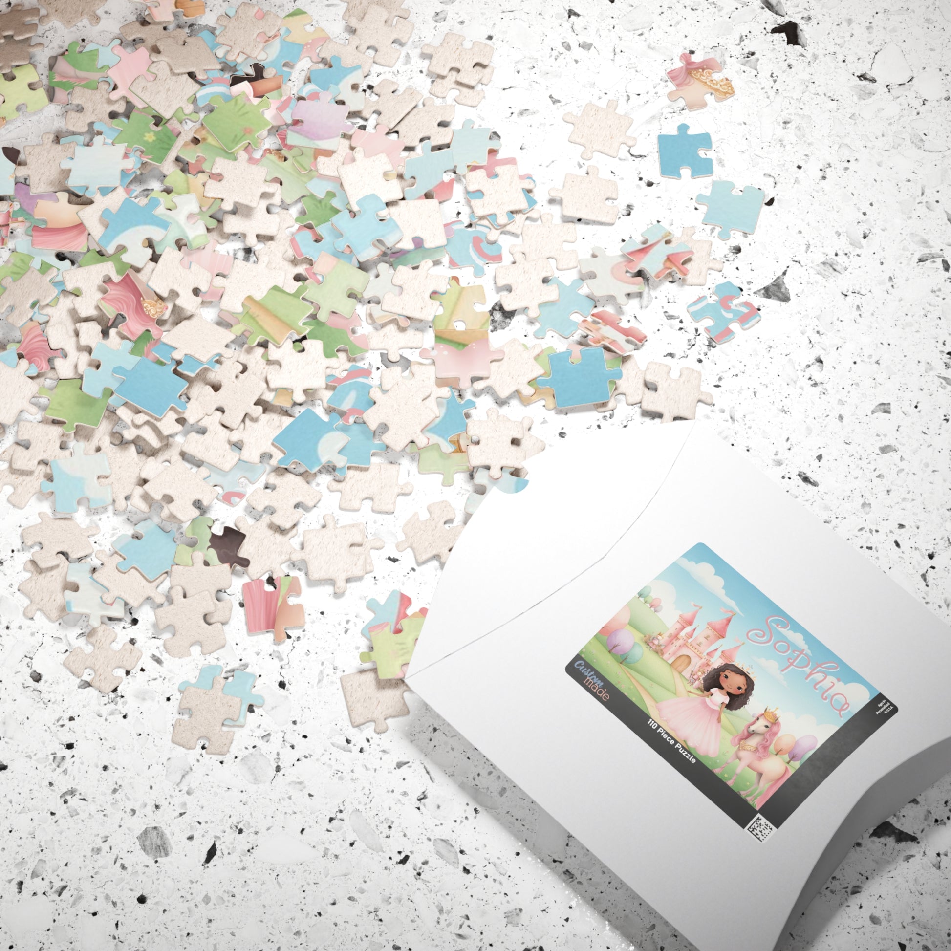 Scattered puzzle pieces on a countertop beside packaging showing a personalized princess puzzle with castle, horse, pastel scenery, and customizable child’s name on the box label.