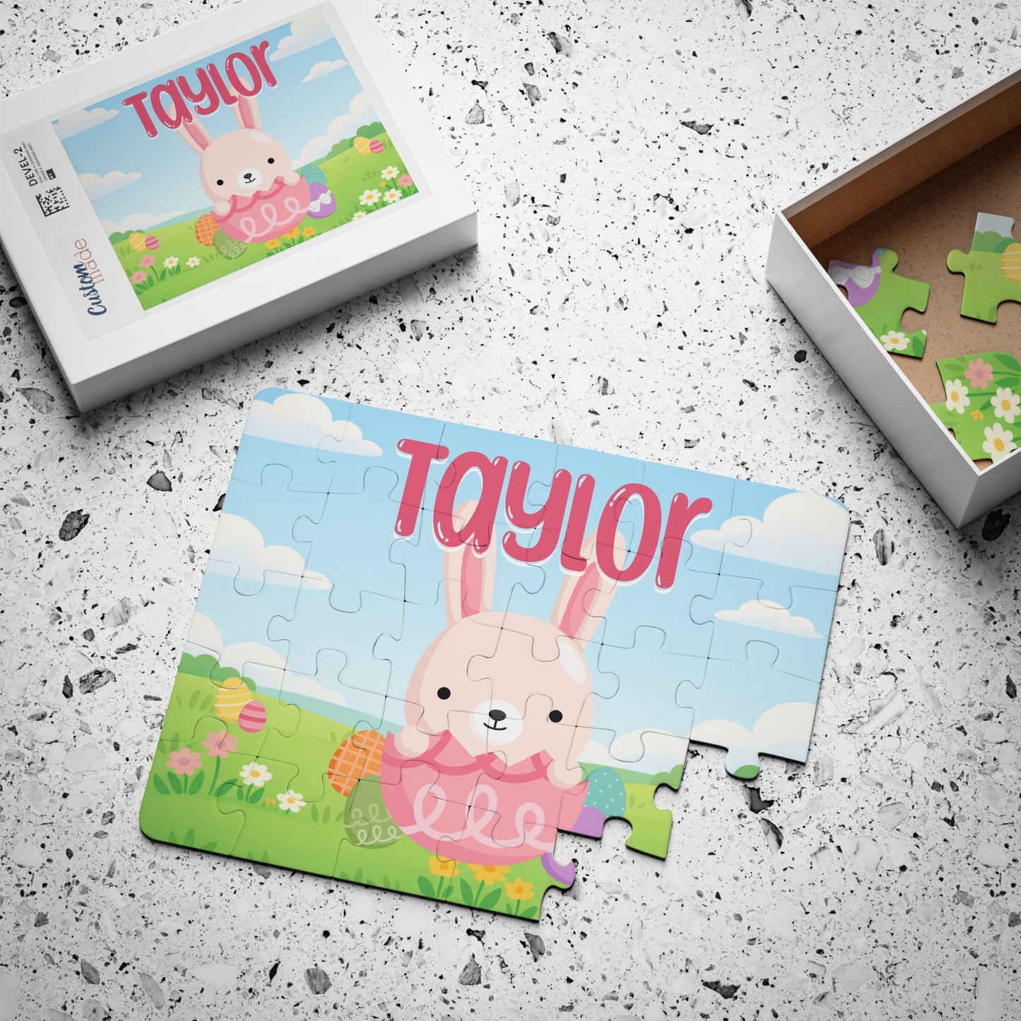 Personalized Easter bunny jigsaw puzzle displayed next to its gift box, featuring a spring bunny design with a customizable name printed at the top and bright seasonal artwork.