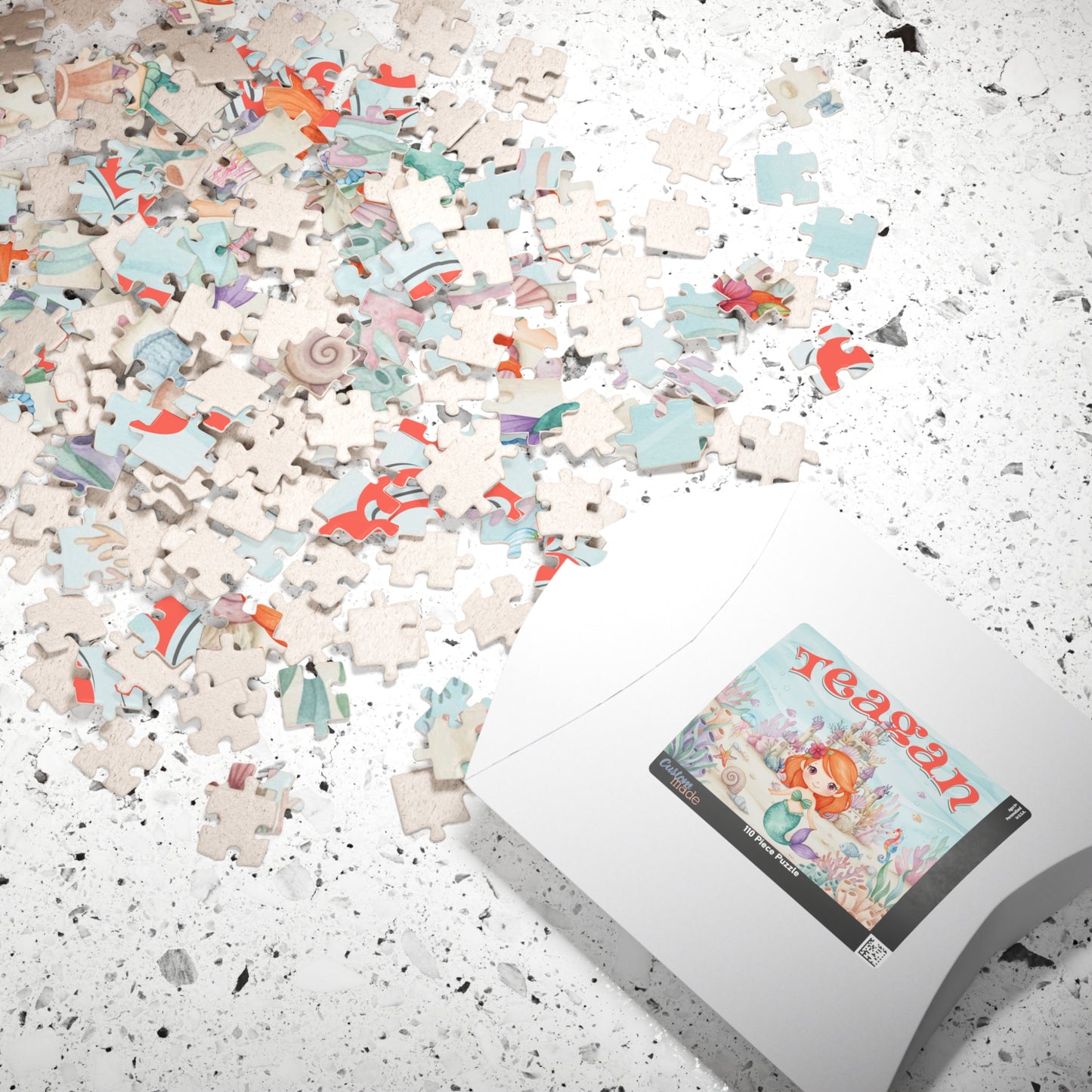 Loose jigsaw puzzle pieces scattered on a surface beside packaging displaying a personalized mermaid underwater scene with ocean castle, sea creatures, and a customizable child’s name on the box.