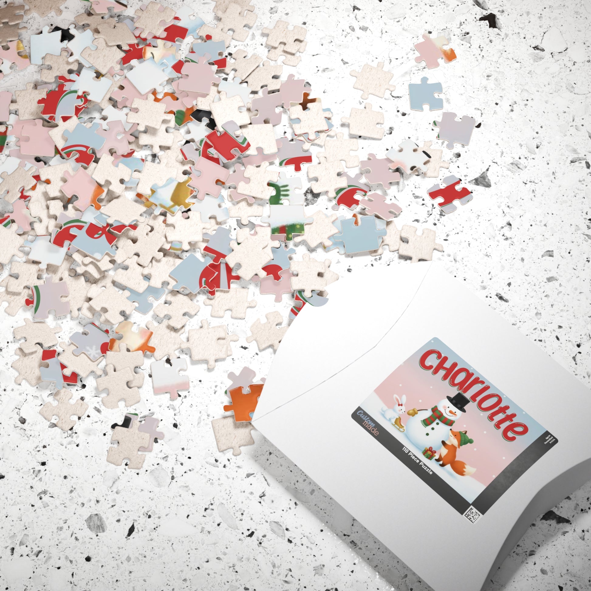 Scattered personalized Christmas puzzle pieces beside the puzzle box featuring a custom snowman, fox, and bunny holiday design.