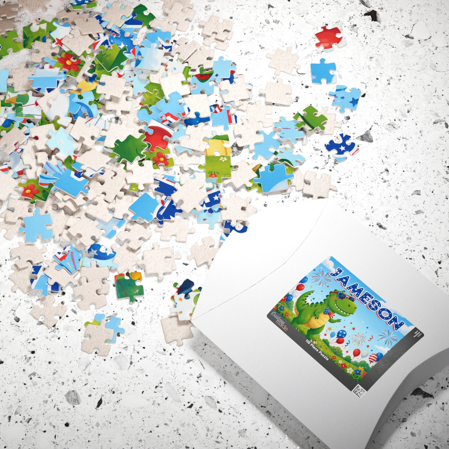 Scattered puzzle pieces and packaging displaying a personalized dinosaur puzzle with custom name, patriotic colors, fireworks, and festive 4th of July design.