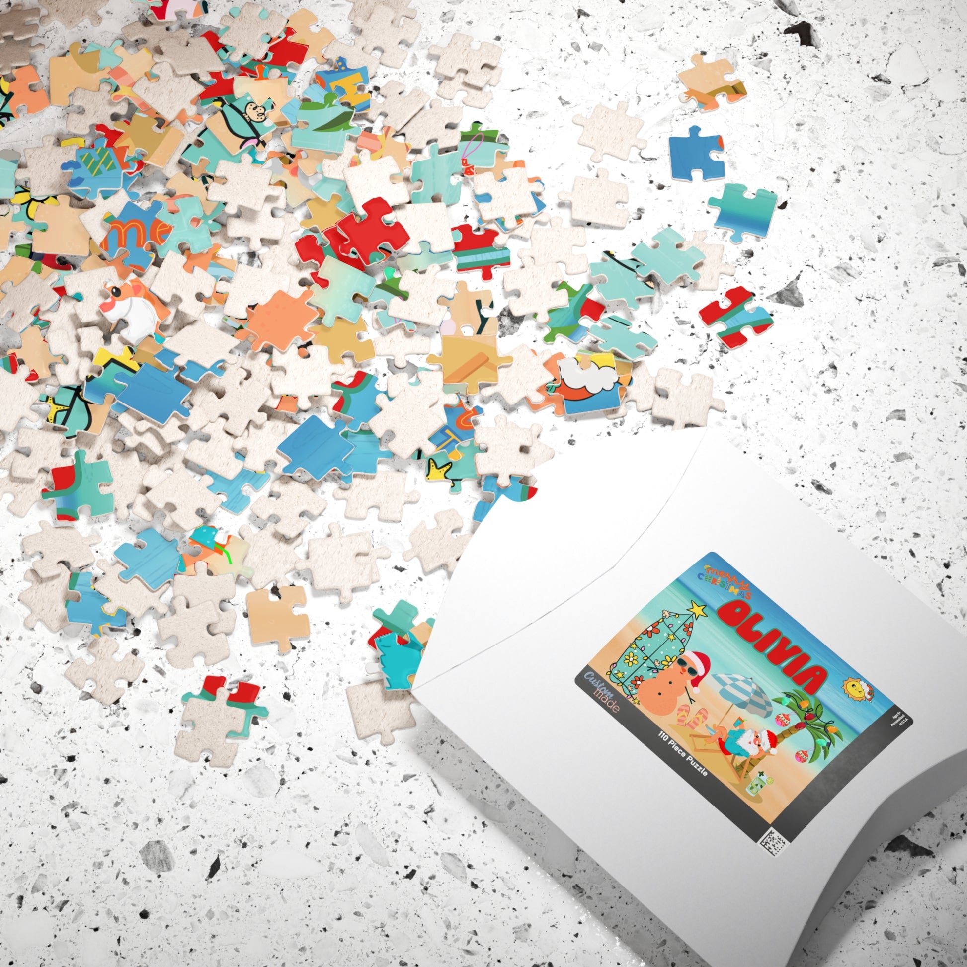 Personalized Christmas puzzle pieces scattered beside the puzzle box featuring a custom beach Christmas scene with Santa relaxing by the ocean.