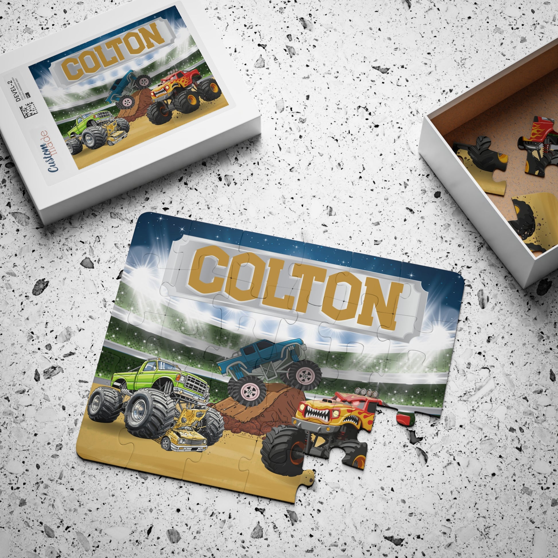 Scattered puzzle pieces next to packaging showing monster truck design with customizable name at the top, highlighting 30-piece puzzle with easy-to-handle pieces for kids.