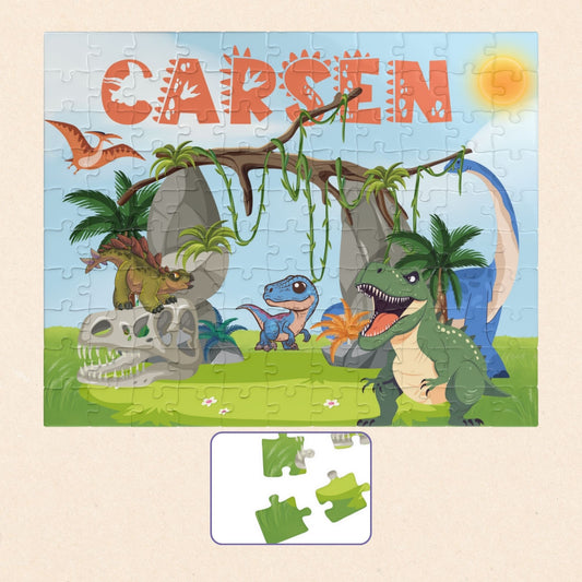 Personalized 110-piece dinosaur jigsaw puzzle for kids featuring a colorful Jurassic scene with multiple cartoon dinosaurs. The child’s name is custom printed at the top of the puzzle, making it a fun and personalized name puzzle gift.